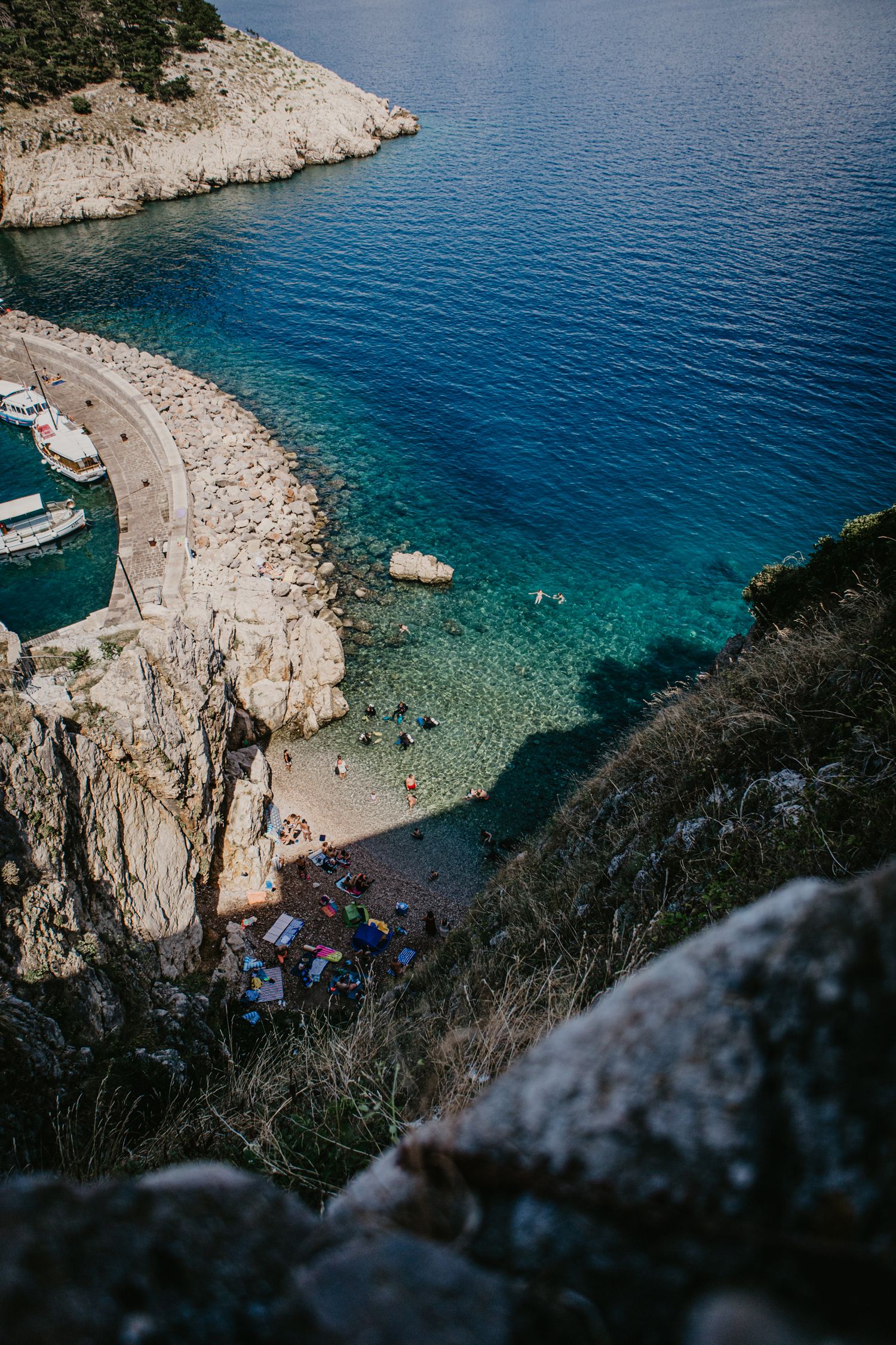 Hidden beach cove surrounded by rocky cliffs with crystal clear turquoise waters.