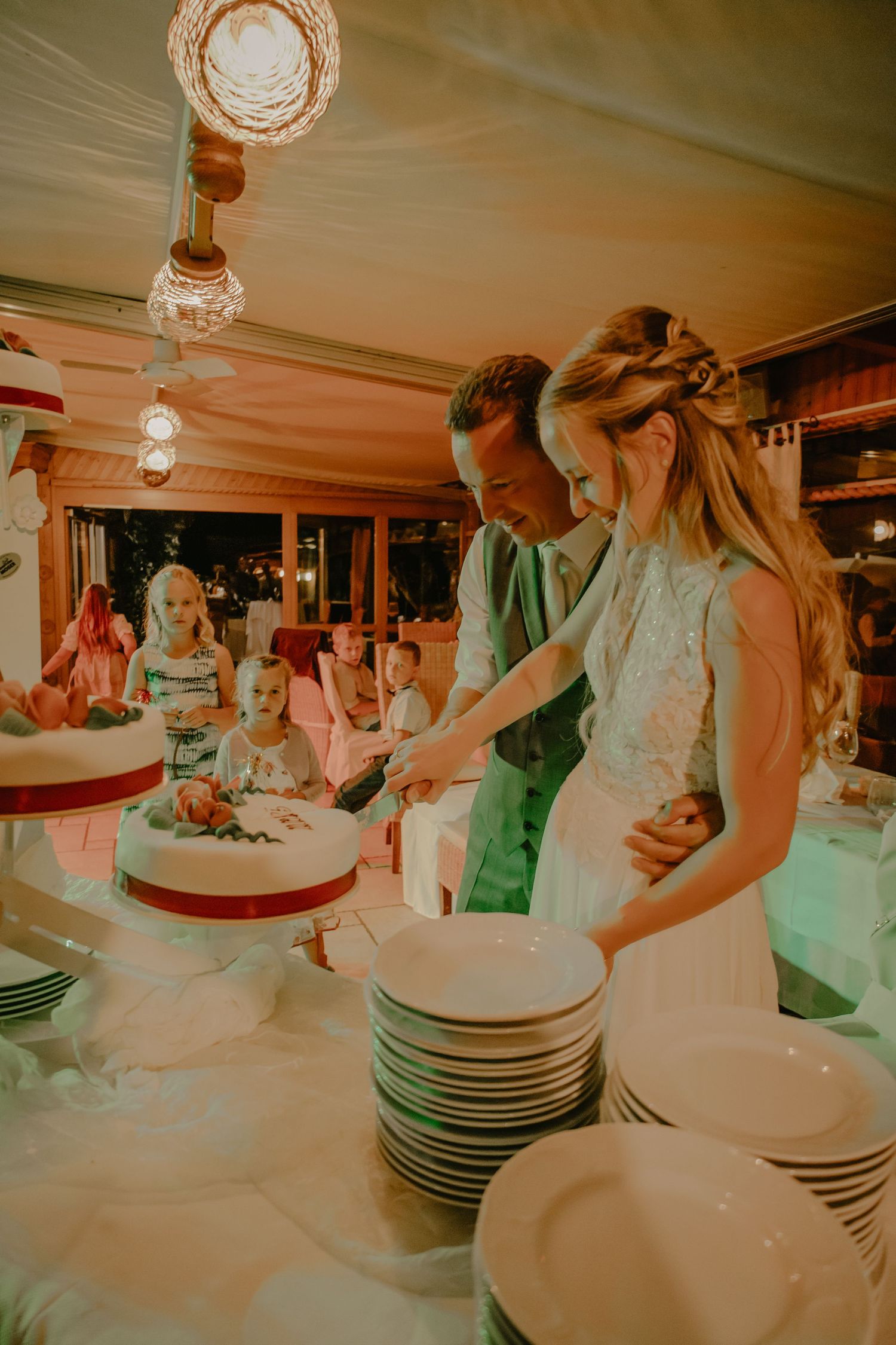 Newlyweds cutting their wedding cake together at the reception.