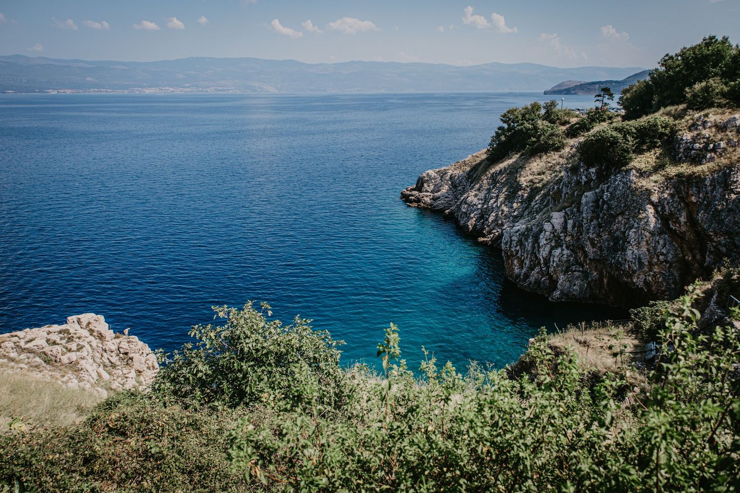 Scenic coastal landscape with blue Mediterranean waters and rocky cliffs.