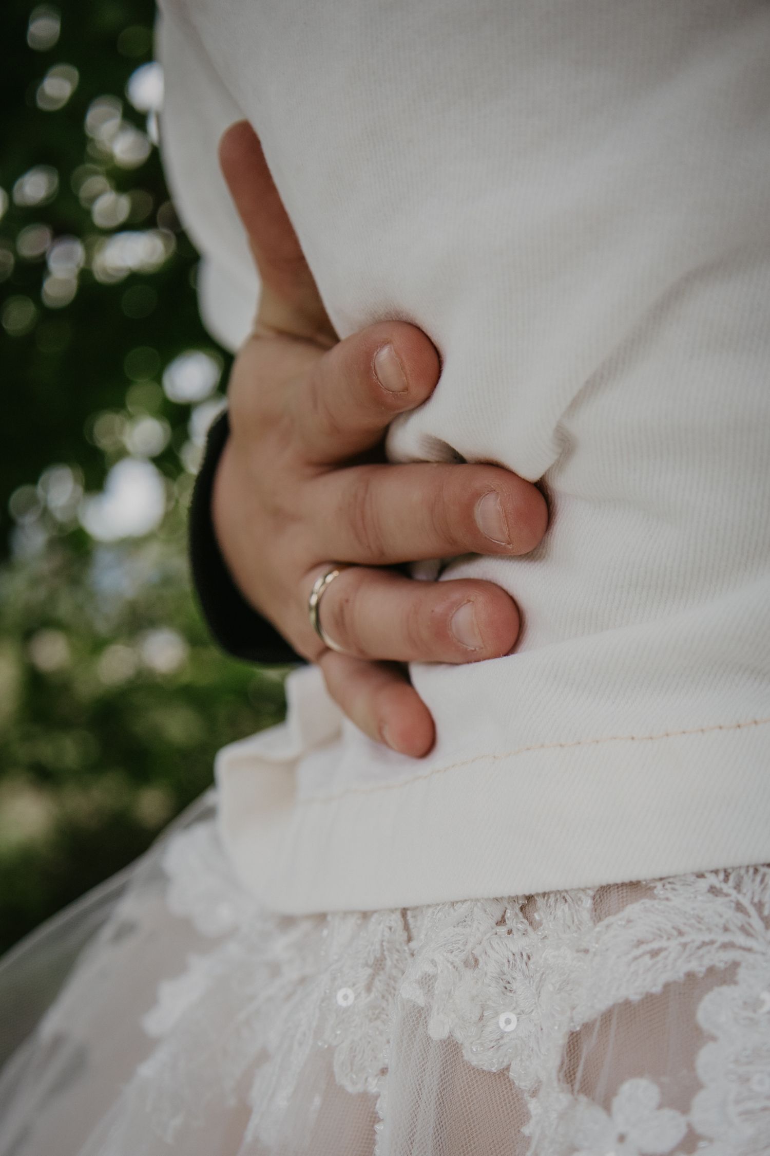 Detail shot of white lace wedding dress with delicate floral appliques.
