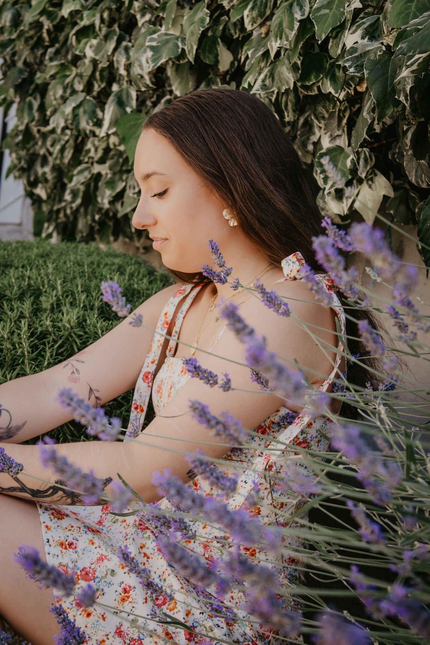 Artistic portrait through blooming lavender stalks in a garden.