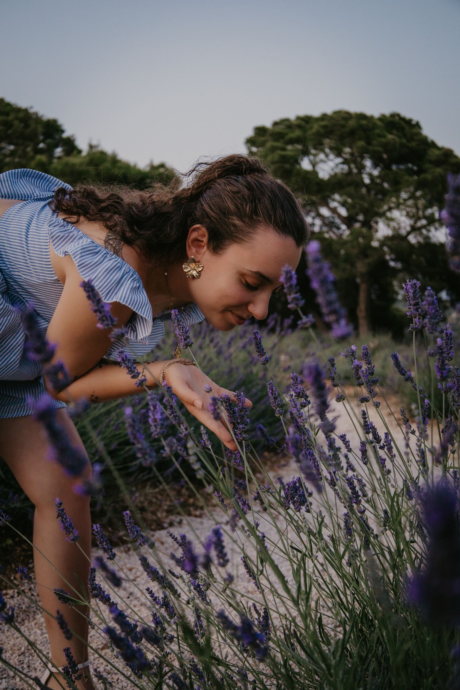 Artistic portrait among blooming lavender plants in evening light.