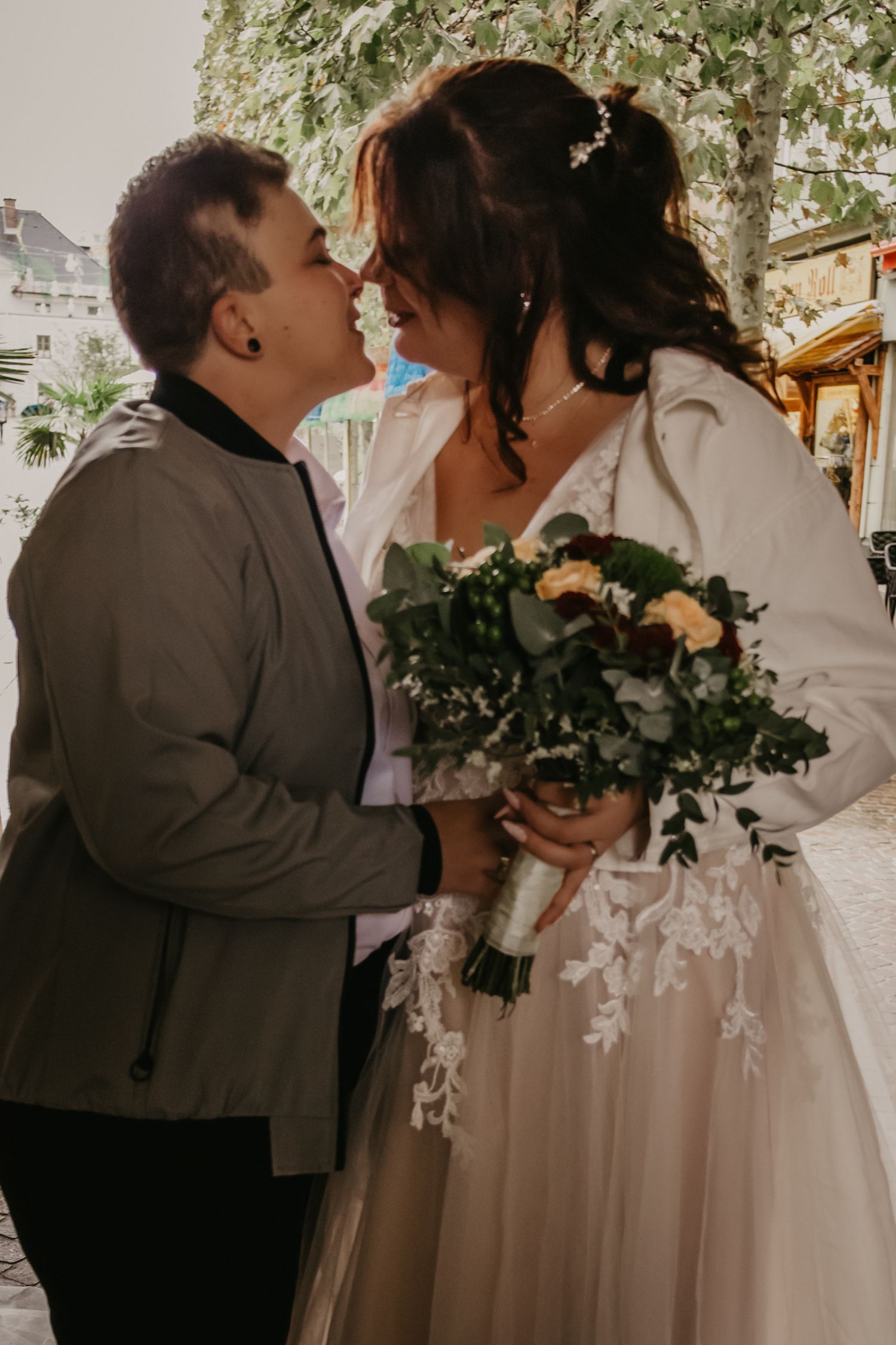 Romantic moment between newlyweds with bride holding floral bouquet.