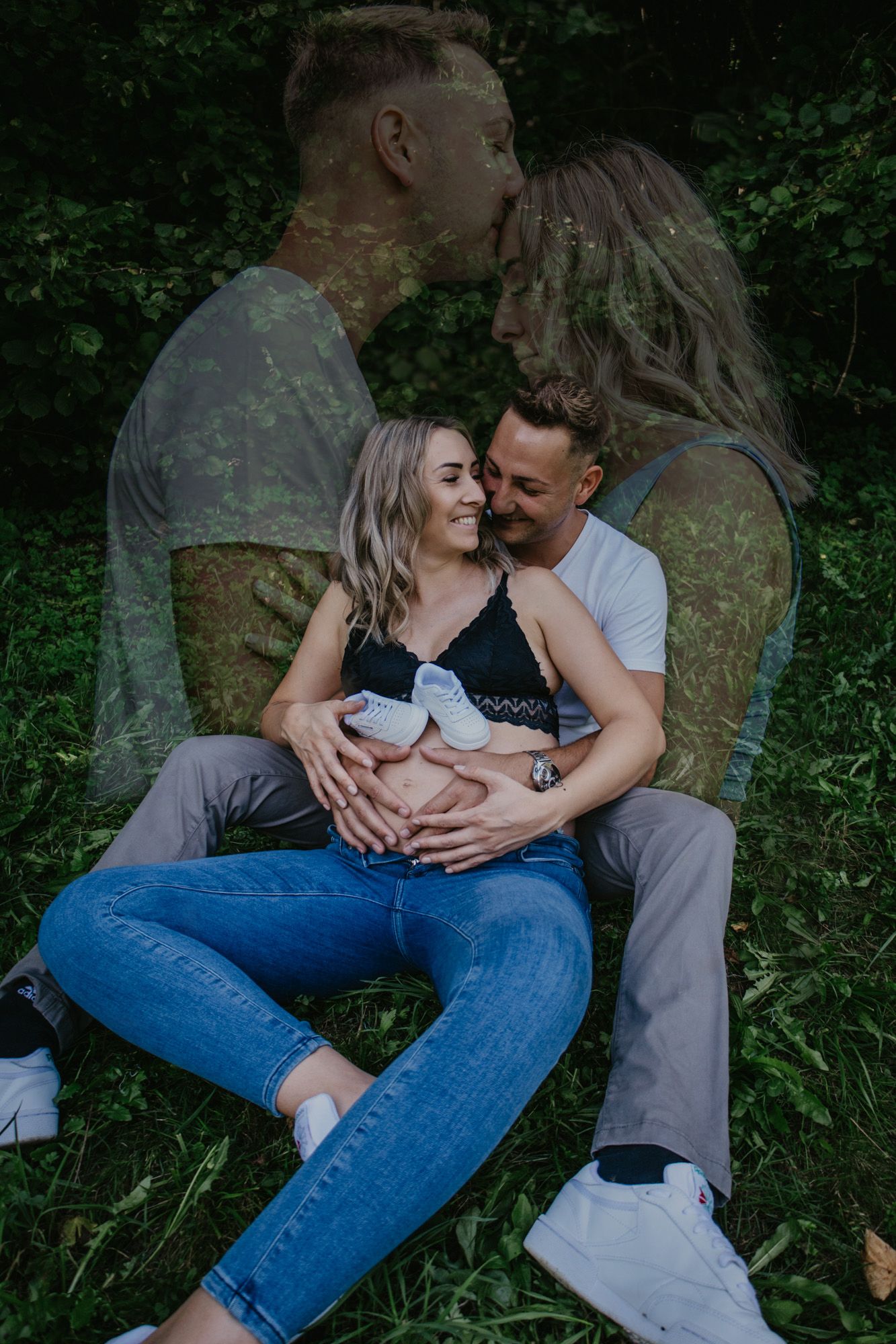 Intimate maternity photos of couple relaxing on grass in natural outdoor setting.