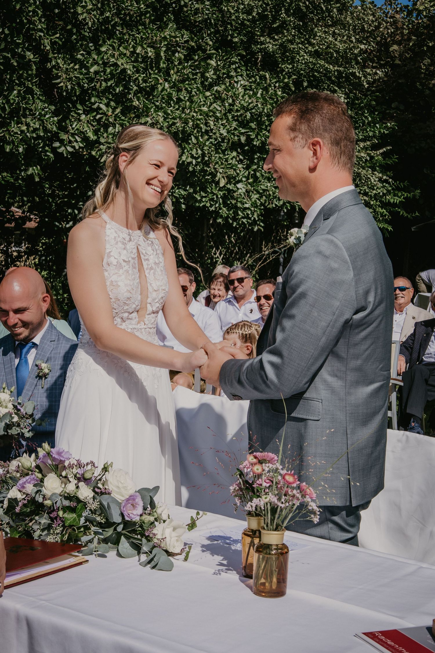 Wedding ceremony table with floral decorations and wooden accents.