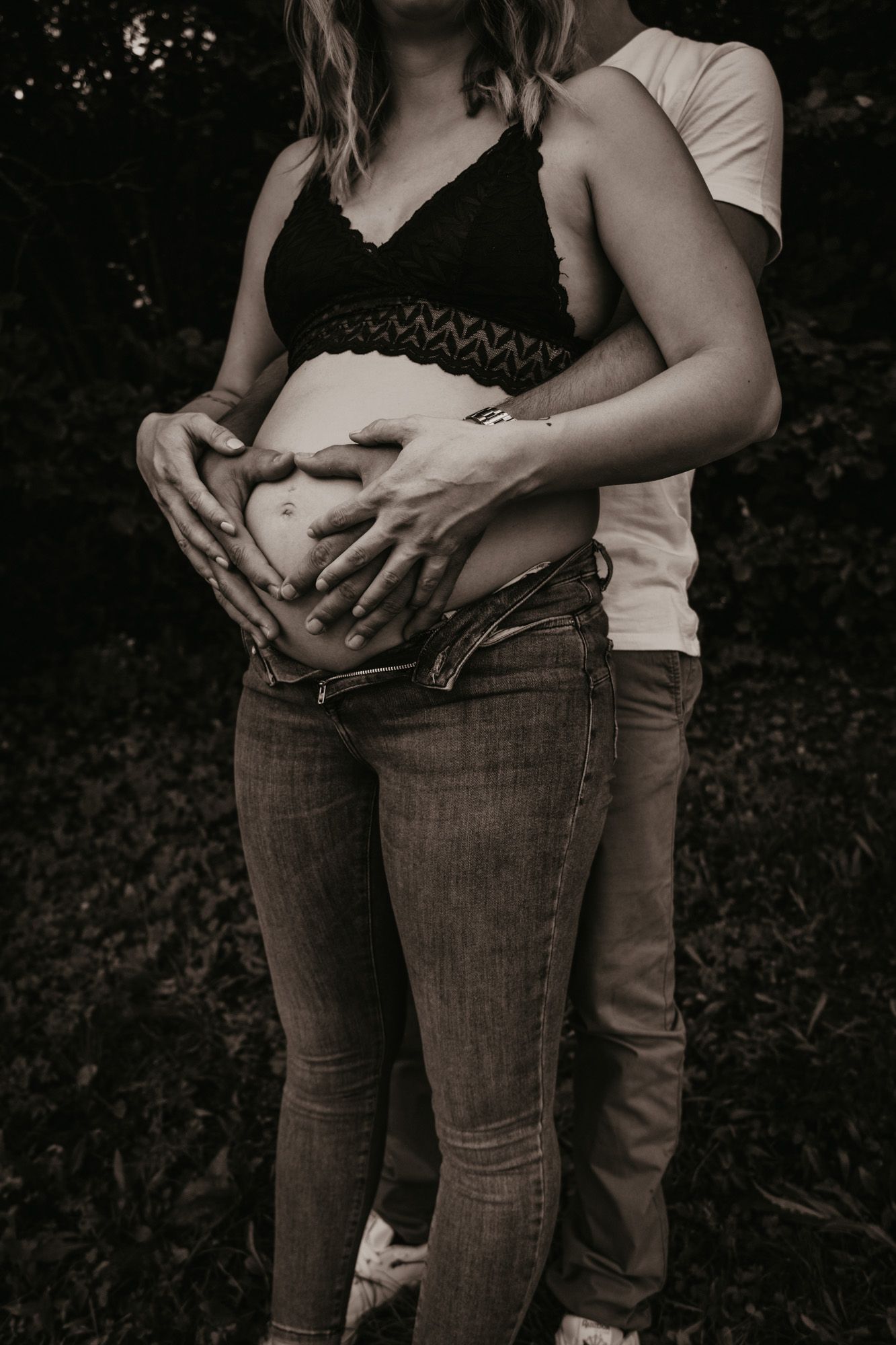 Intimate black and white photos of a couple showing pregnancy belly.