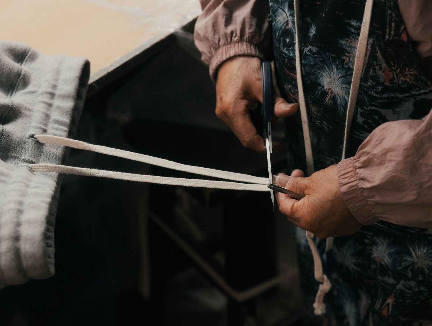 Hands weaving natural reed strips in traditional basket-making craft technique.