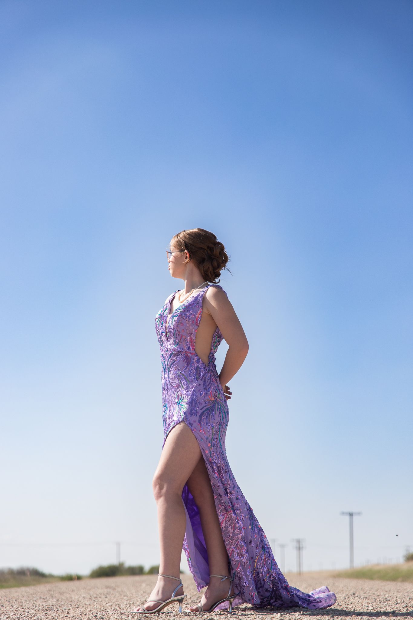A flowing purple gown creates dramatic silhouettes against a bright desert landscape.