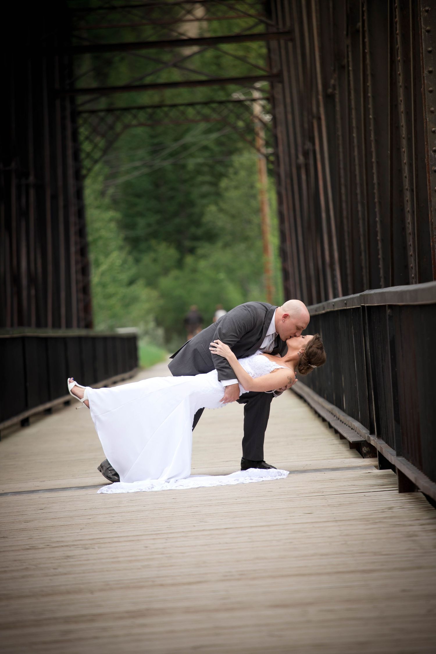 Romantic sequence showing couple in wedding attire sharing intimate moments on a wooden bridge.