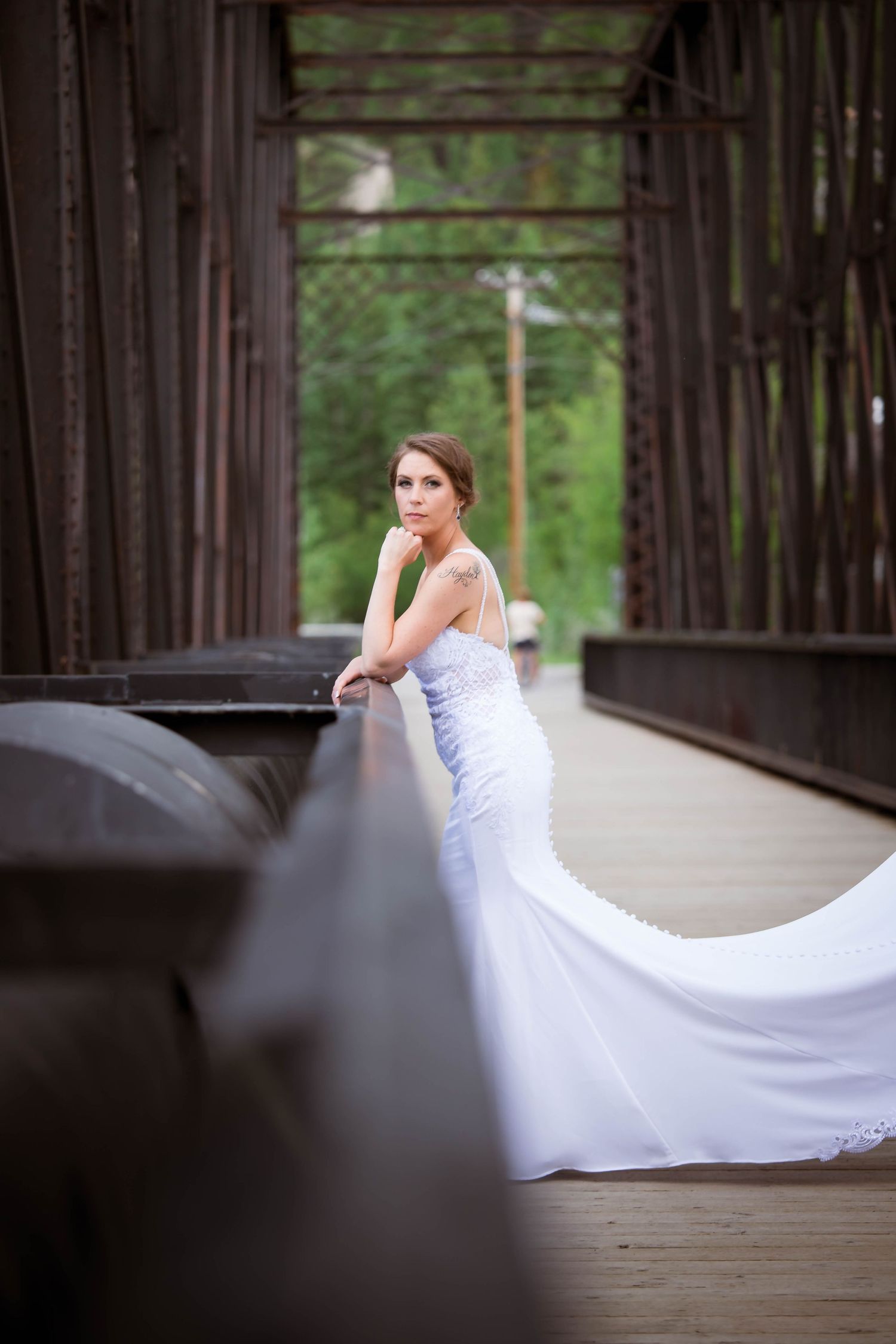 Bride's white wedding dress trails beautifully across wooden bridge in artistic photo sequence.