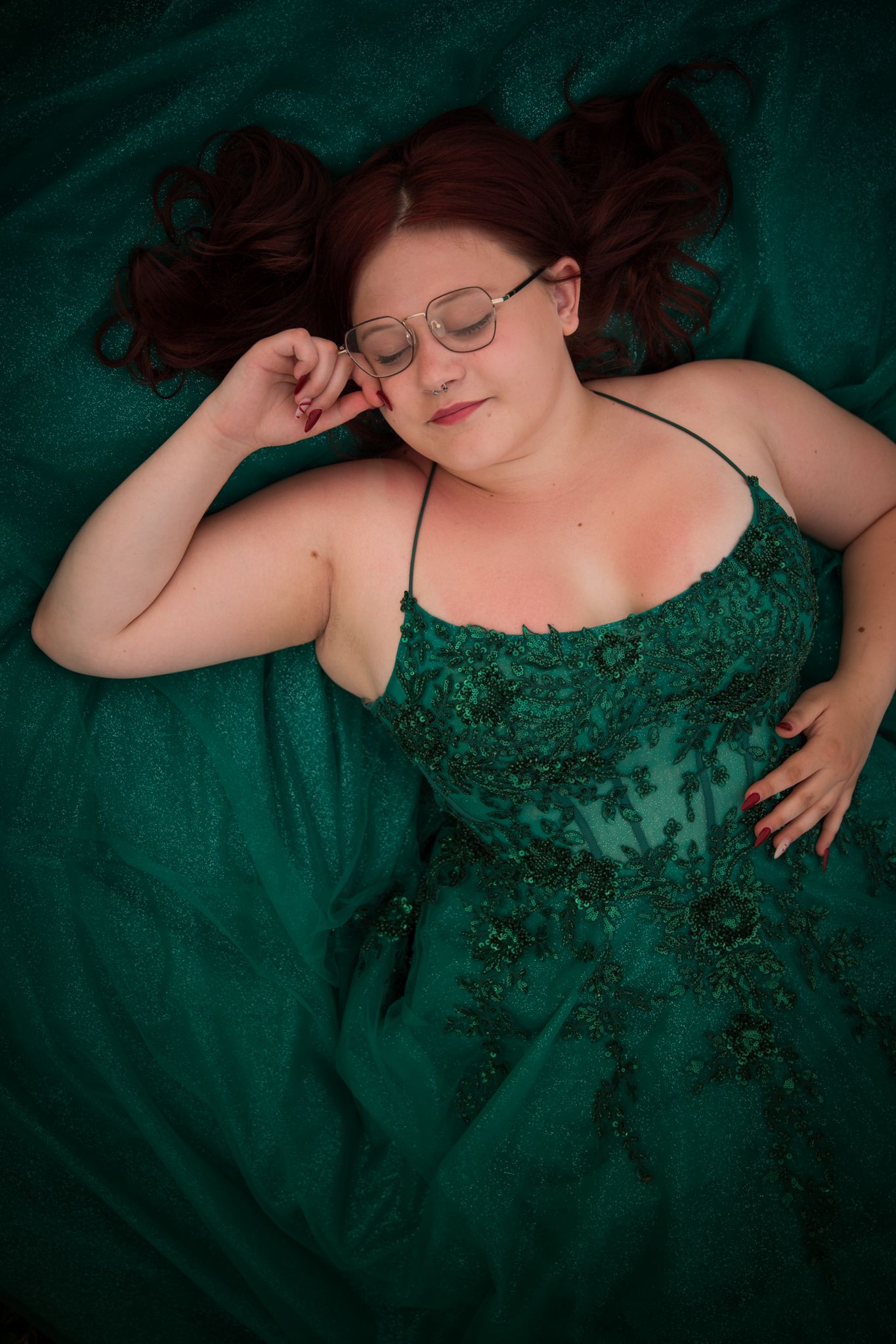 Artistic overhead shot featuring emerald green formal dress with intricate beading.