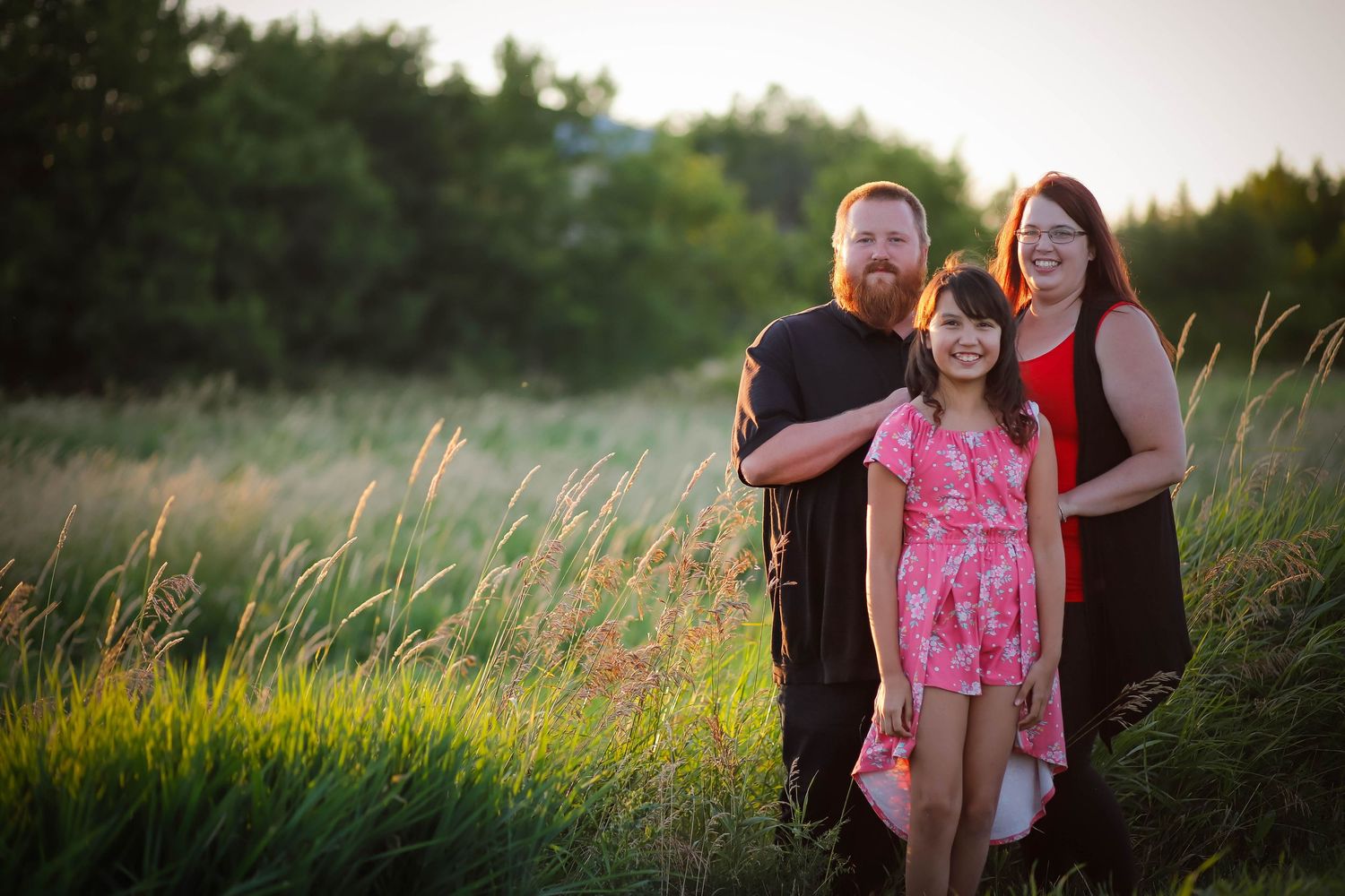 Candid outdoor family portraits in a natural setting with warm evening light.