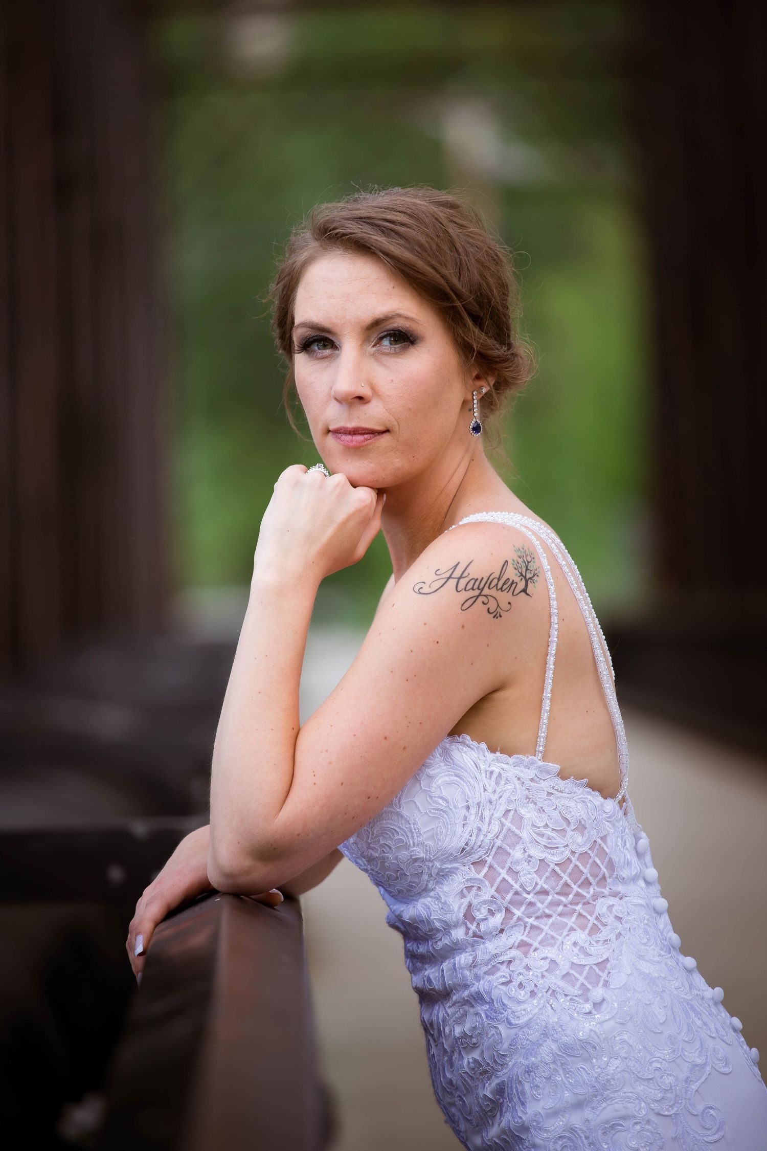 Artistic bridal portrait series showing bride in lace dress on wooden bridge.