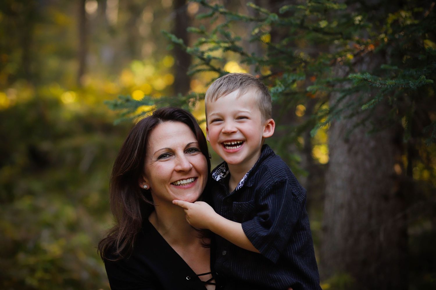 Candid family moments captured in a wooded setting with autumn colors.