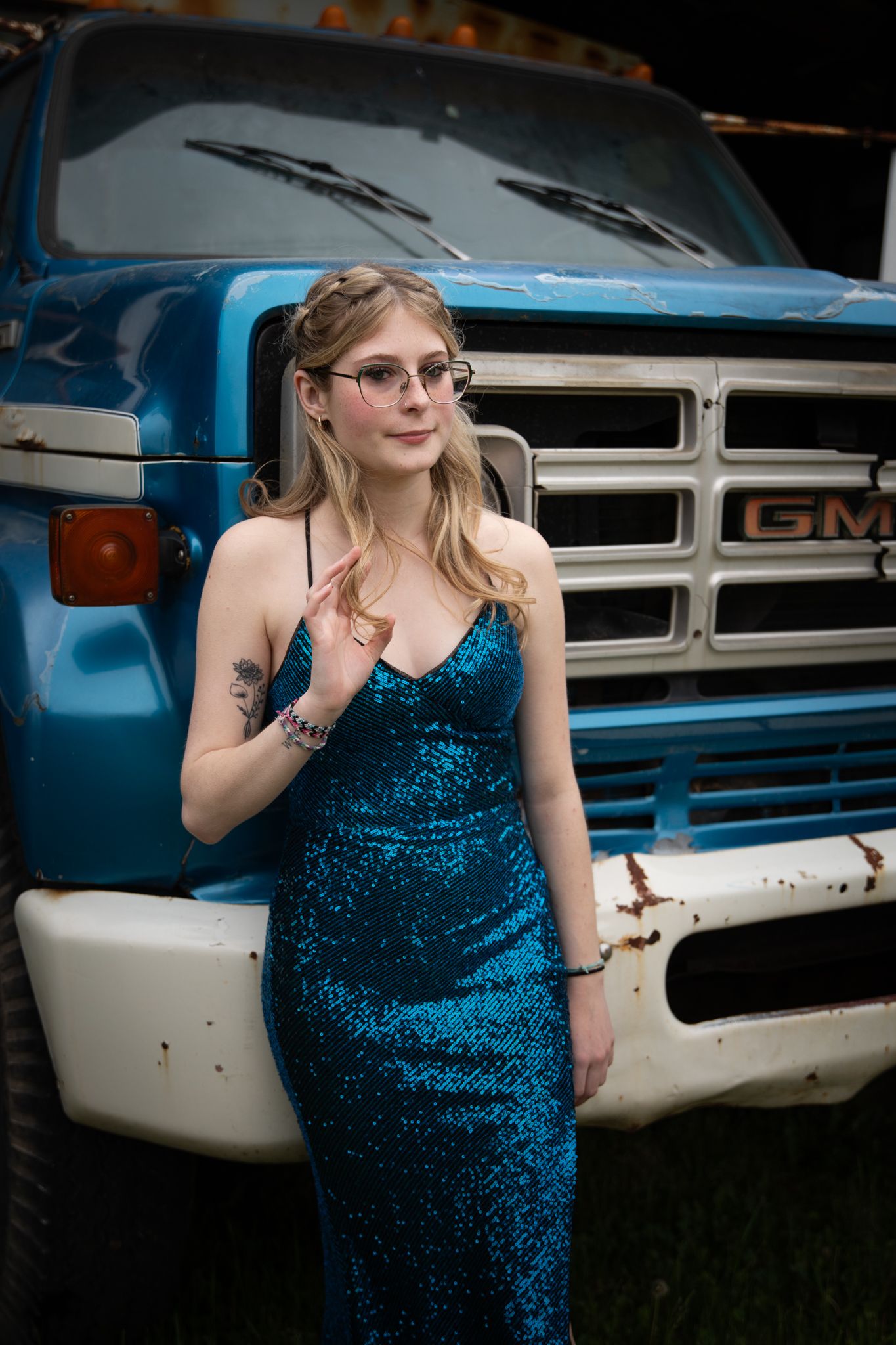 Retro photoshoot featuring blue sequin dress against classic GMC truck exterior.