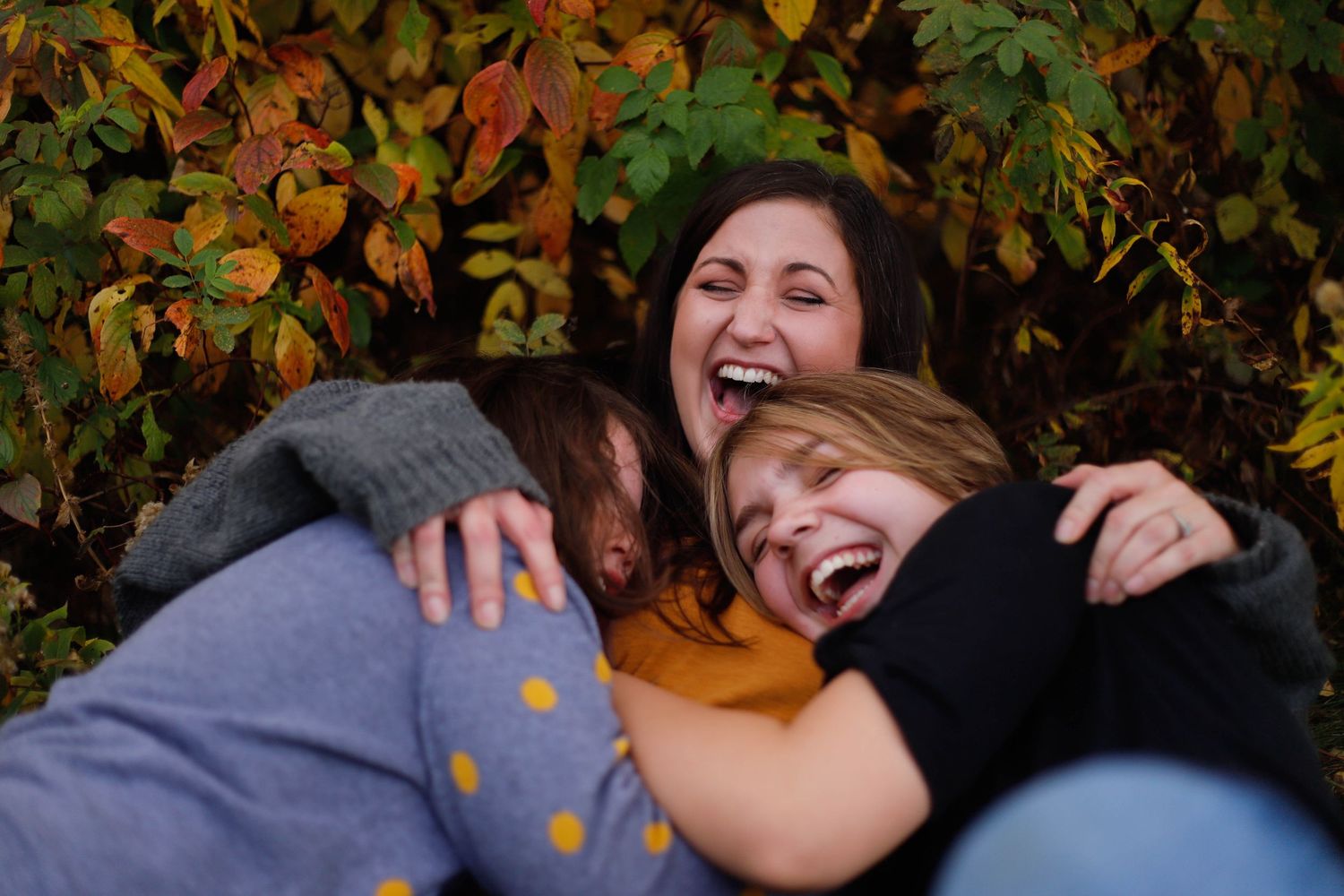 Playful family moments captured against autumn foliage backdrop.