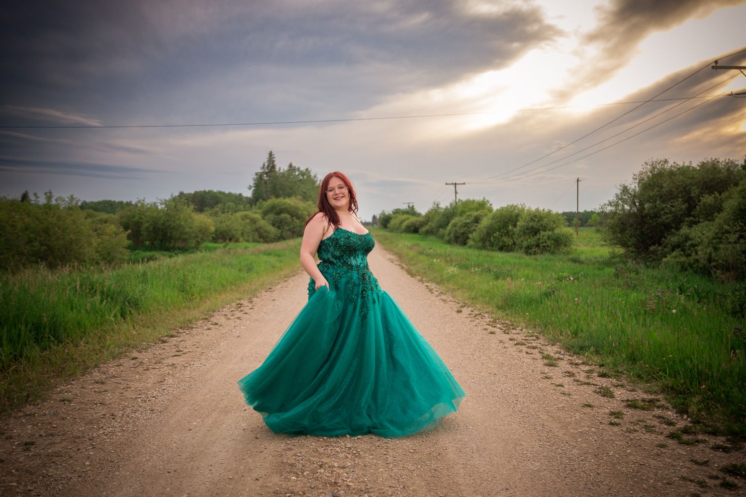 Flowing emerald dress photographed on rural dirt path at golden hour.