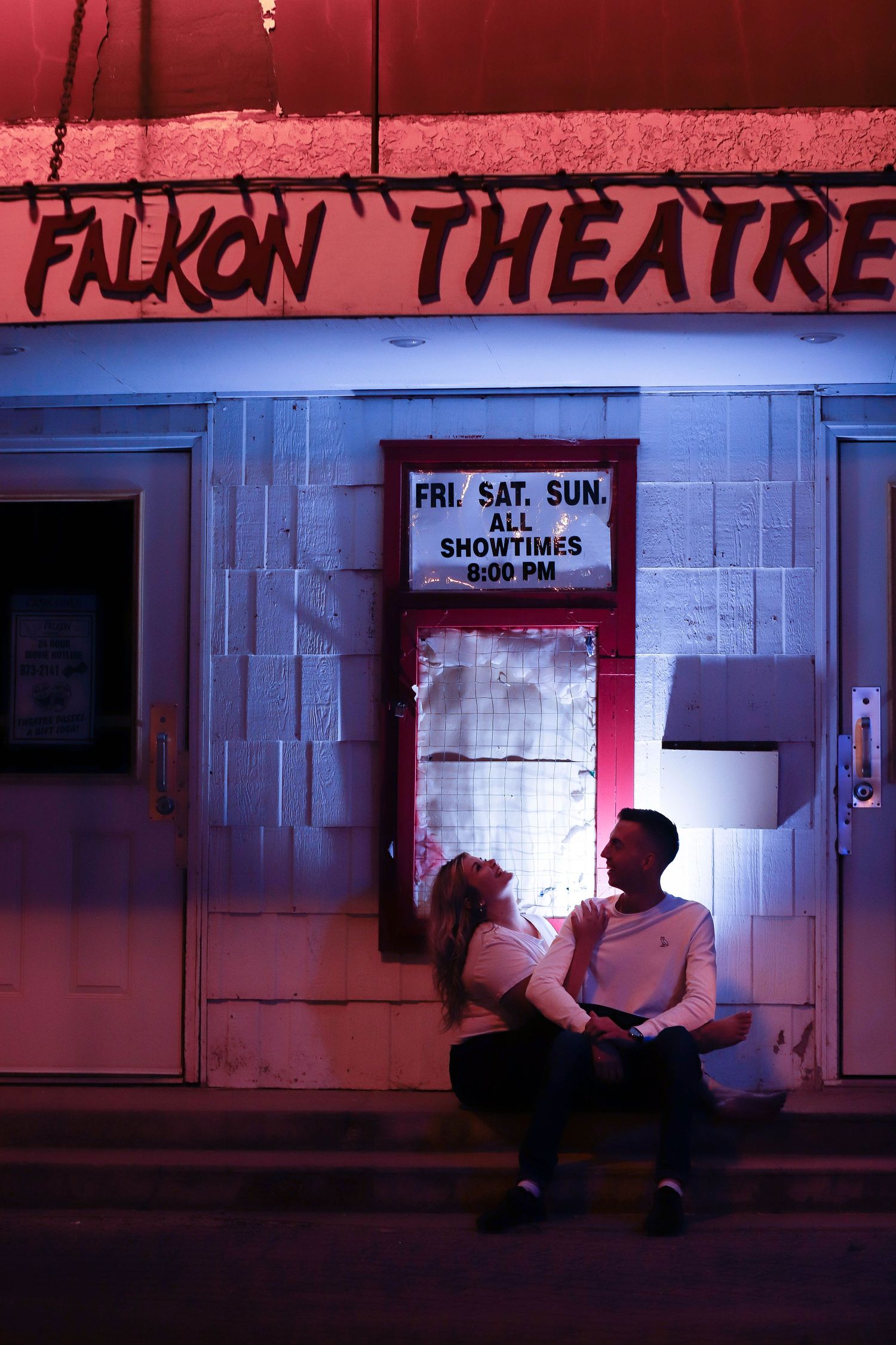 Moody red-tinted nighttime photographs of the Falcon Theatre exterior and entrance.