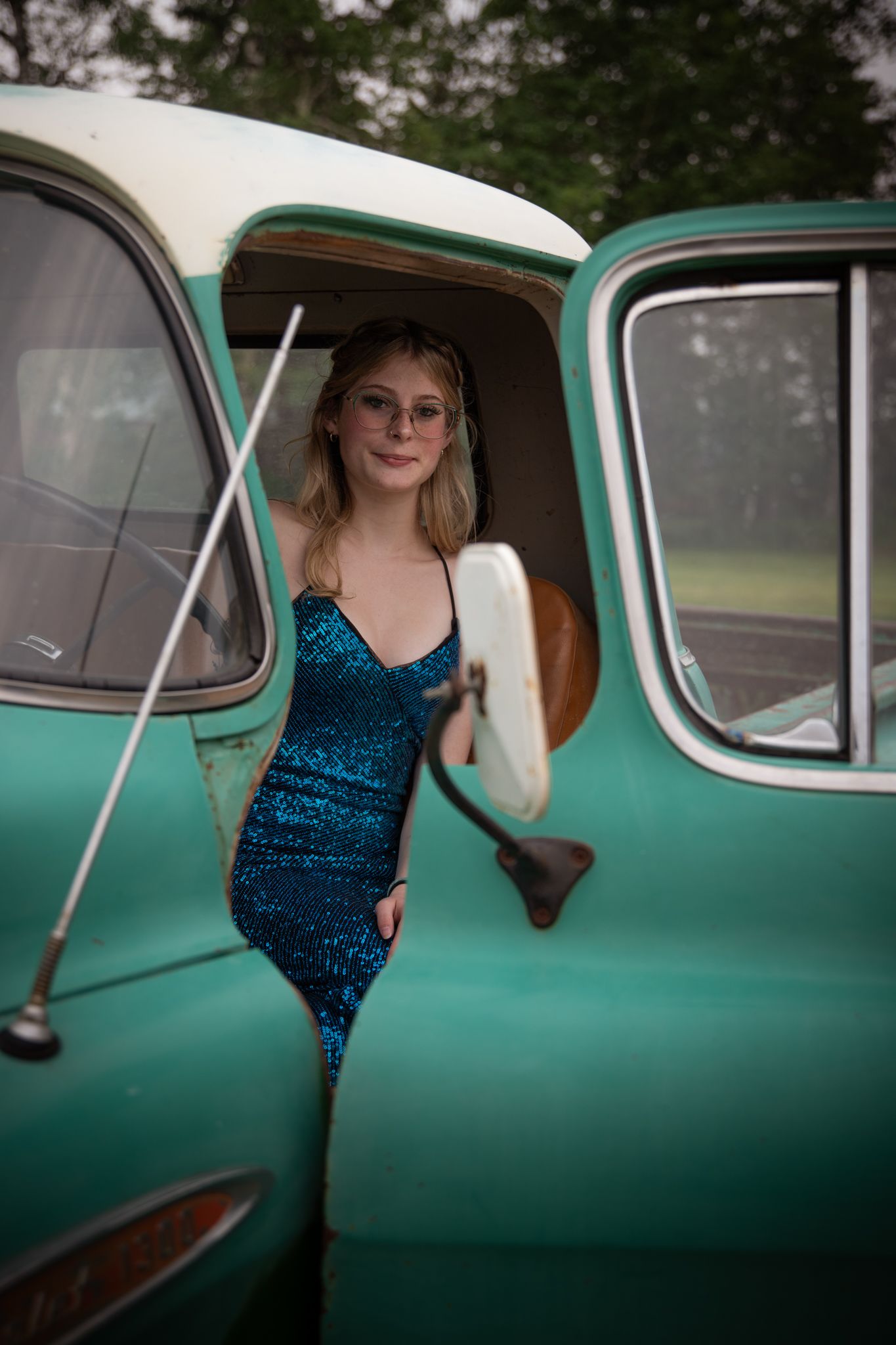 Vintage turquoise car serves as stylish backdrop for fashion photography.