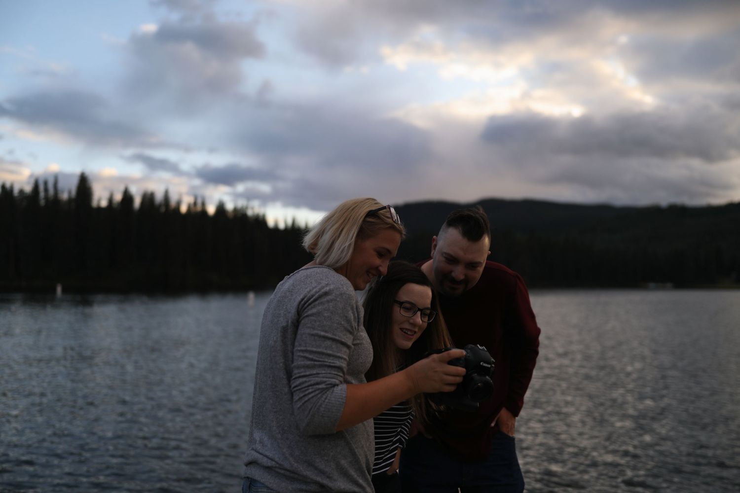 A romantic photoshoot sequence by a lake during golden hour with mountains in the background.