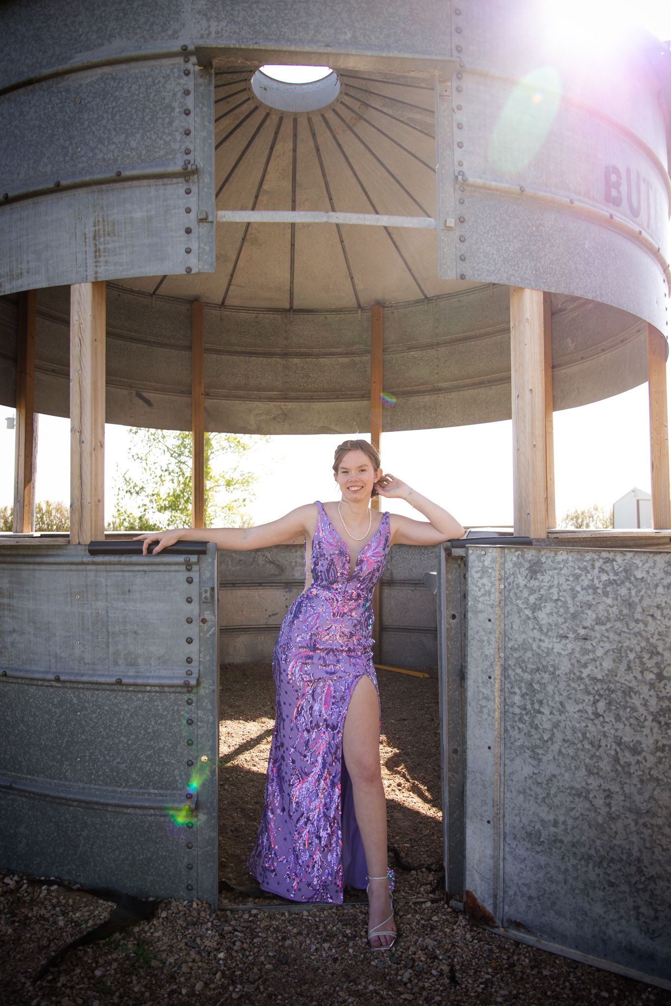 A shimmering purple dress photographed in various poses under a concrete pavilion structure.