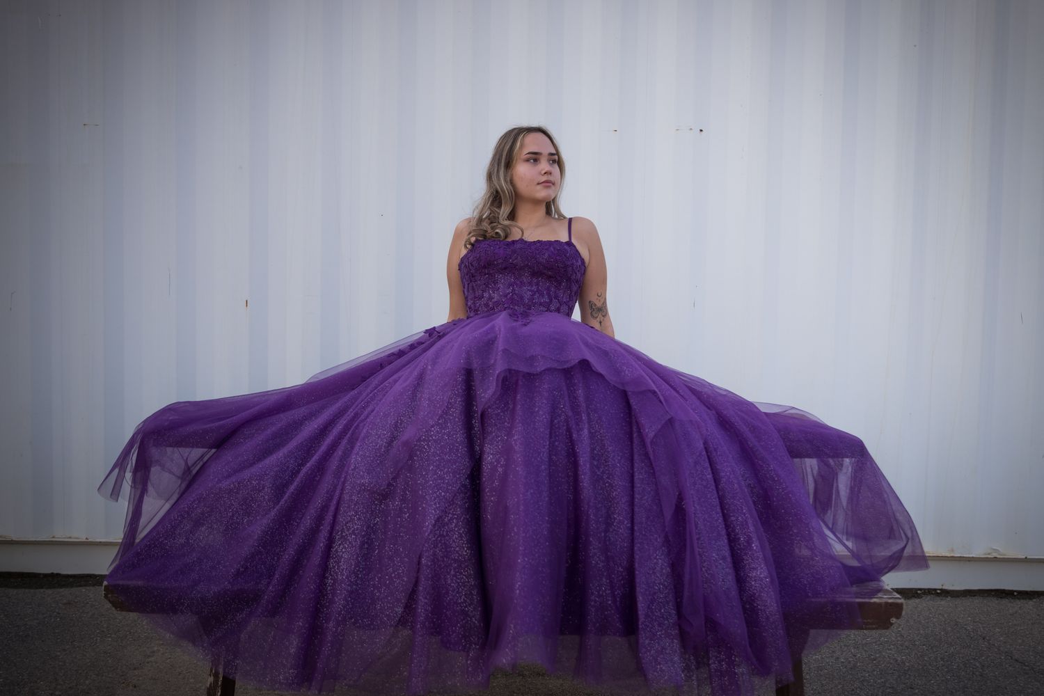 A flowing purple ball gown dress photographed against a white background.