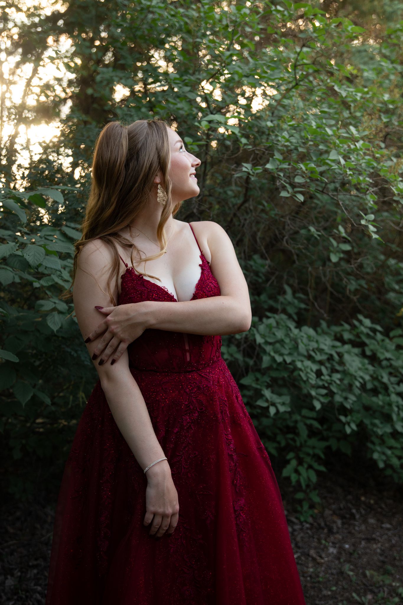 A burgundy formal dress captured in an artistic outdoor portrait session.