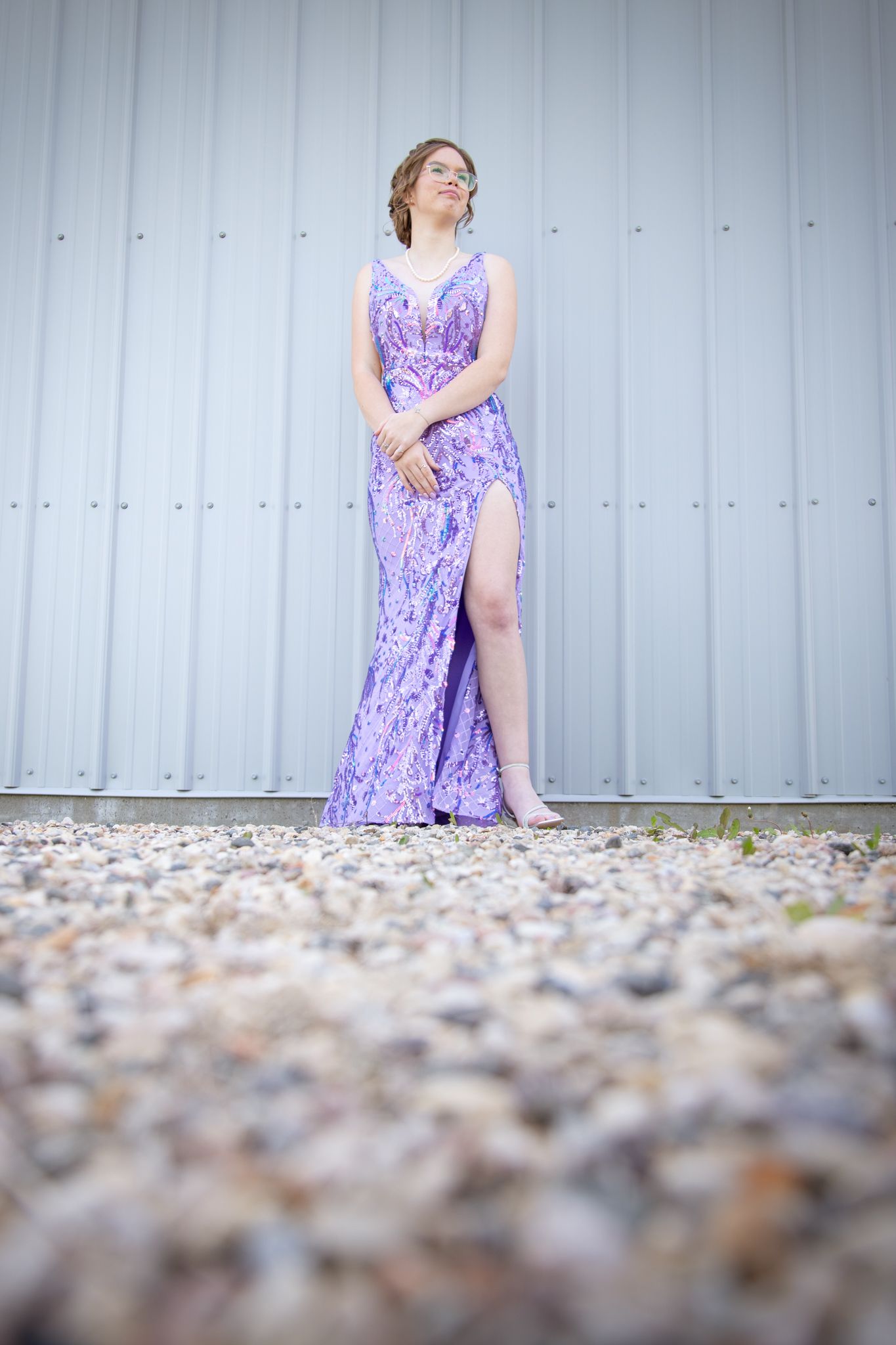 A purple sparkly dress contrasts against an industrial metal wall backdrop.