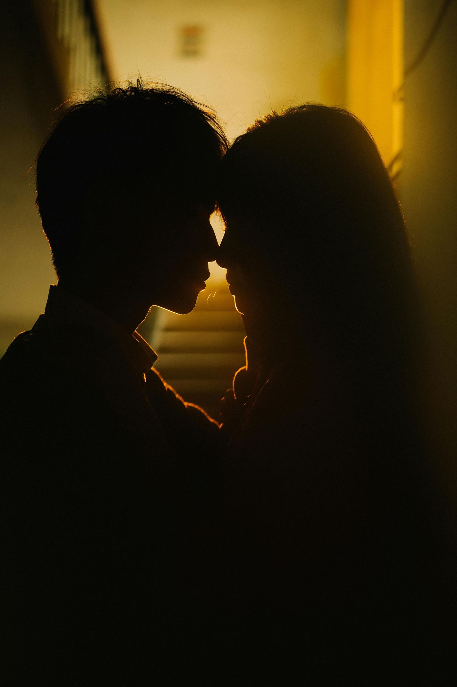 Couple inside studio capturing a loving moment in a lowlight environment for photo