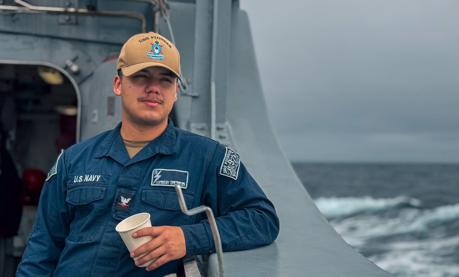 Candid at sea portrait photo shoot of a man in uniform standing on a naval ship