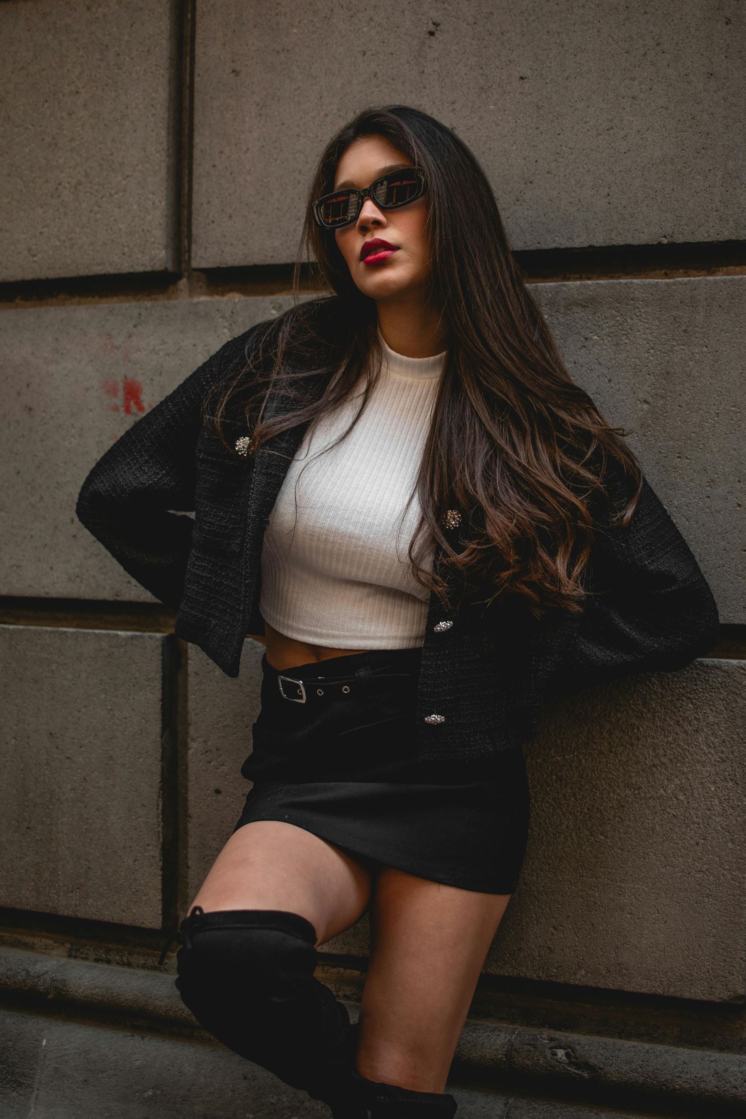 Fashion portrait session of a woman wearing sunglasses in a city setting with natural light
