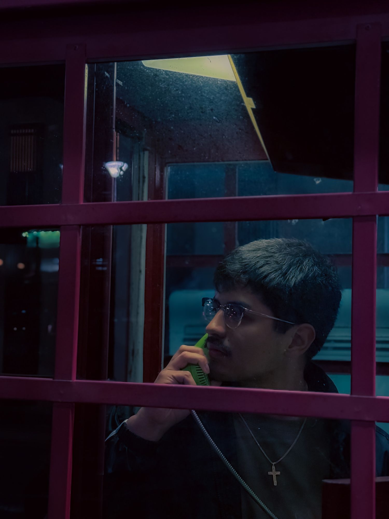 A cinematic portrait photo of Bryant Bucio in a phone booth in sasebo japan