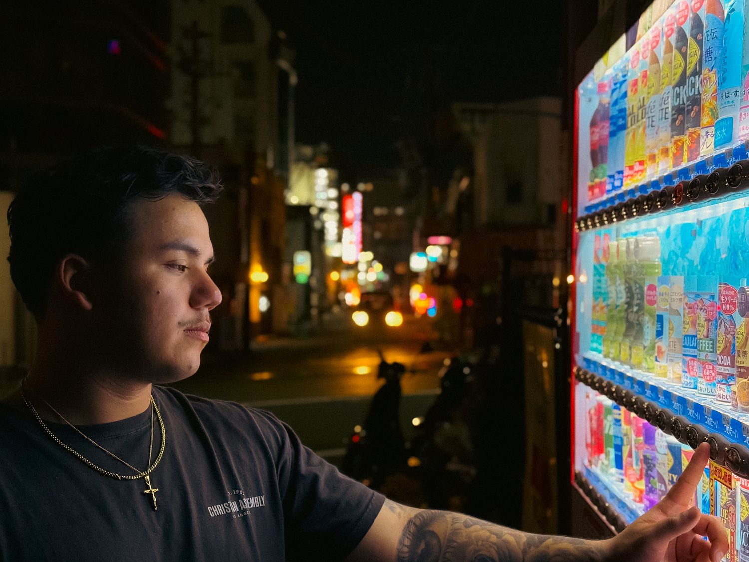 Cinematic urban portrait of a man at night illuminated by city lights and a colorful vending machine
