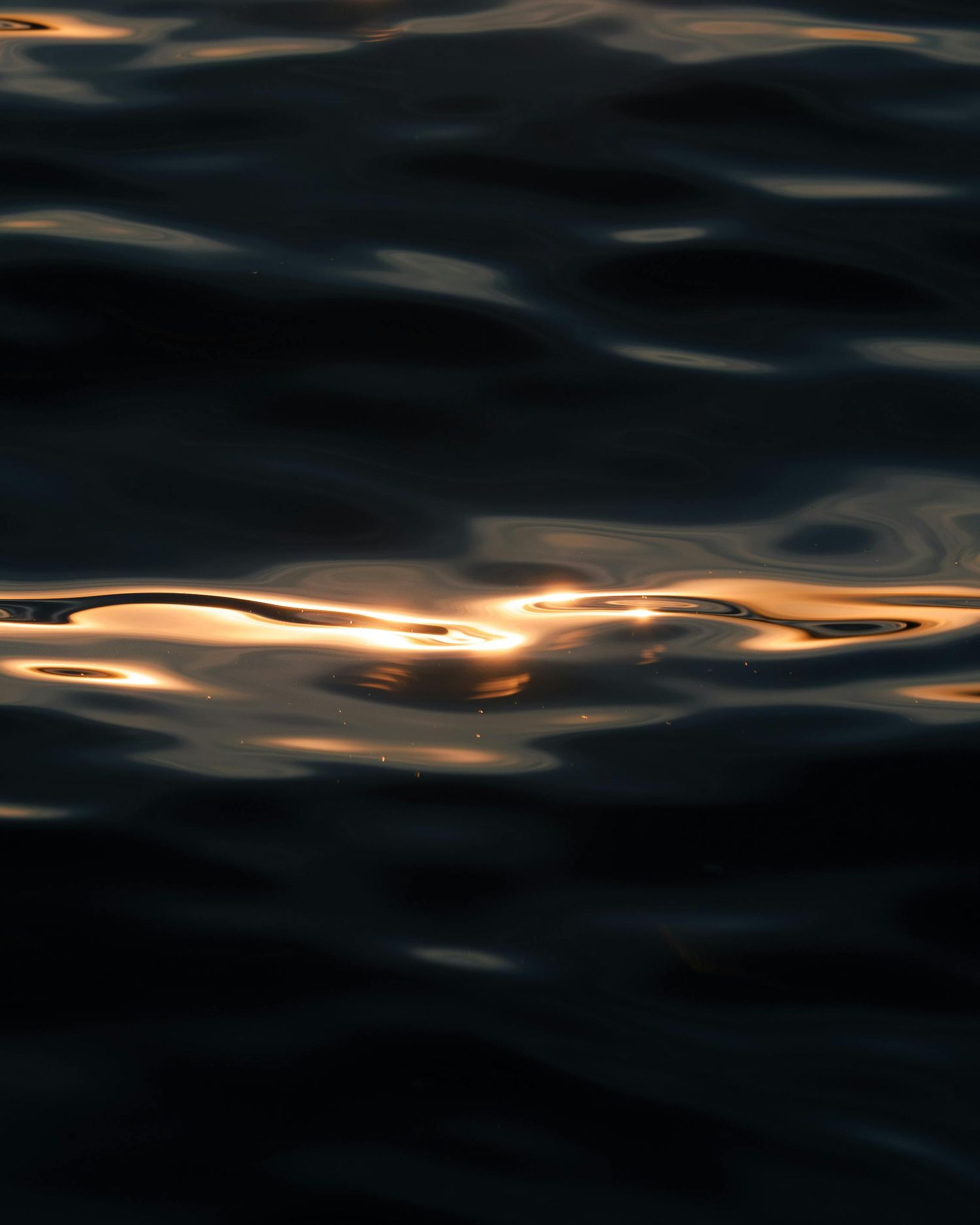 Photo of the ocean water with some reflection of the sun taken during sunset