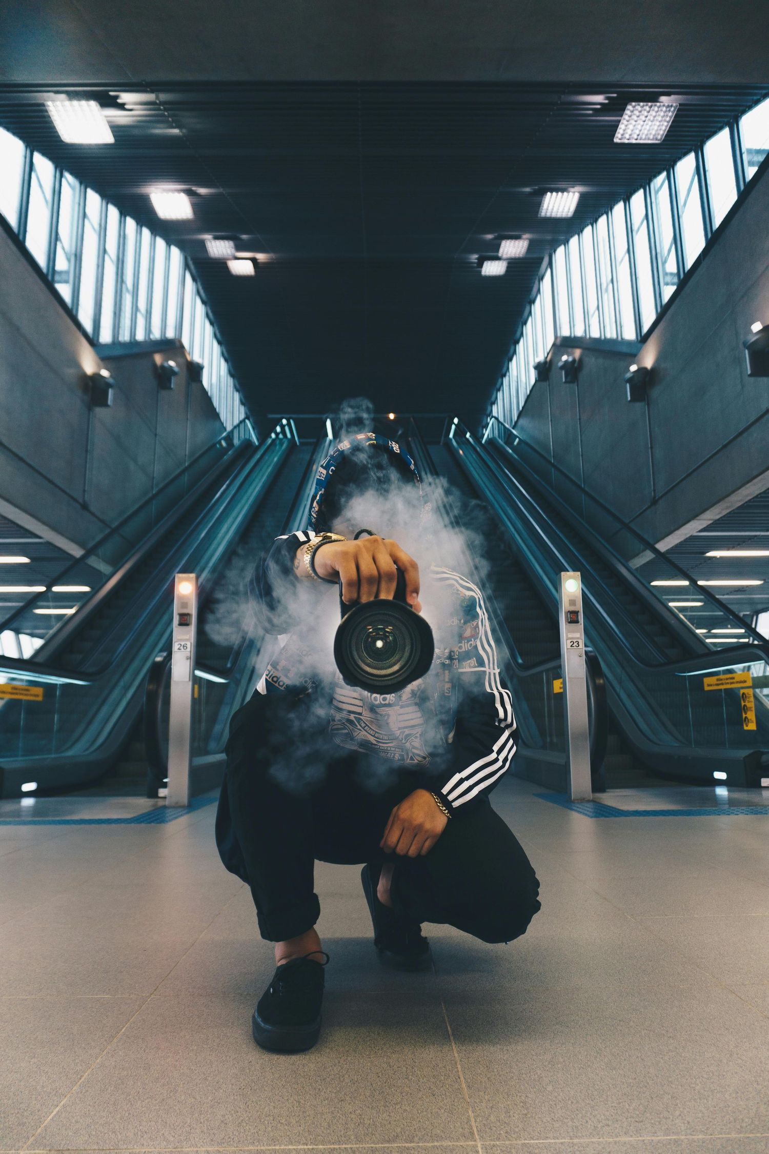 Photo of photographer in a station with fog taking photos