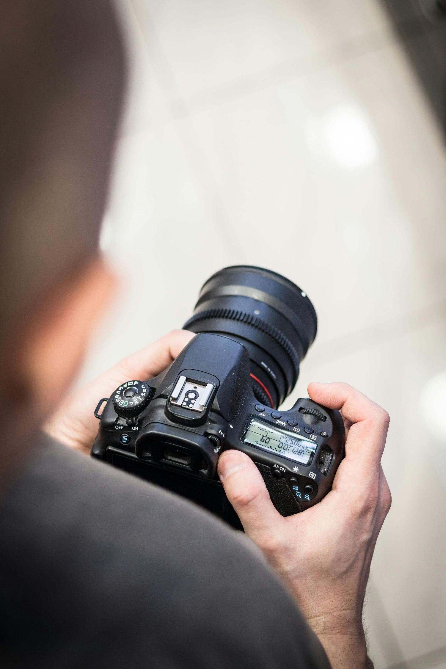 Photographer holding his camera in the studio while capturing a portrait session