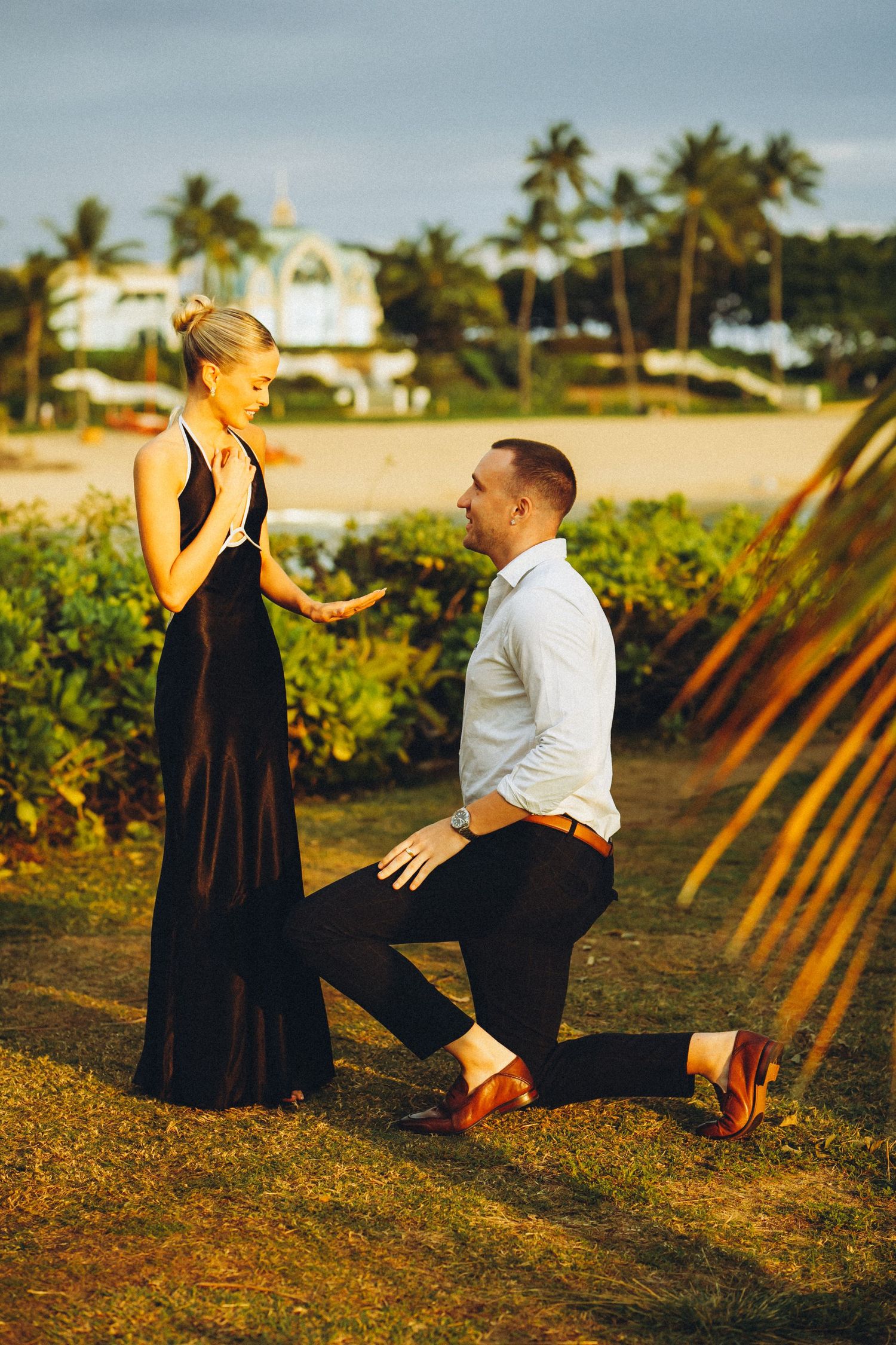 Sunset proposal photography in Ko Olina, Oahu. A groom-to-be proposing to his fiancée during a golden hour session in Hawaii.