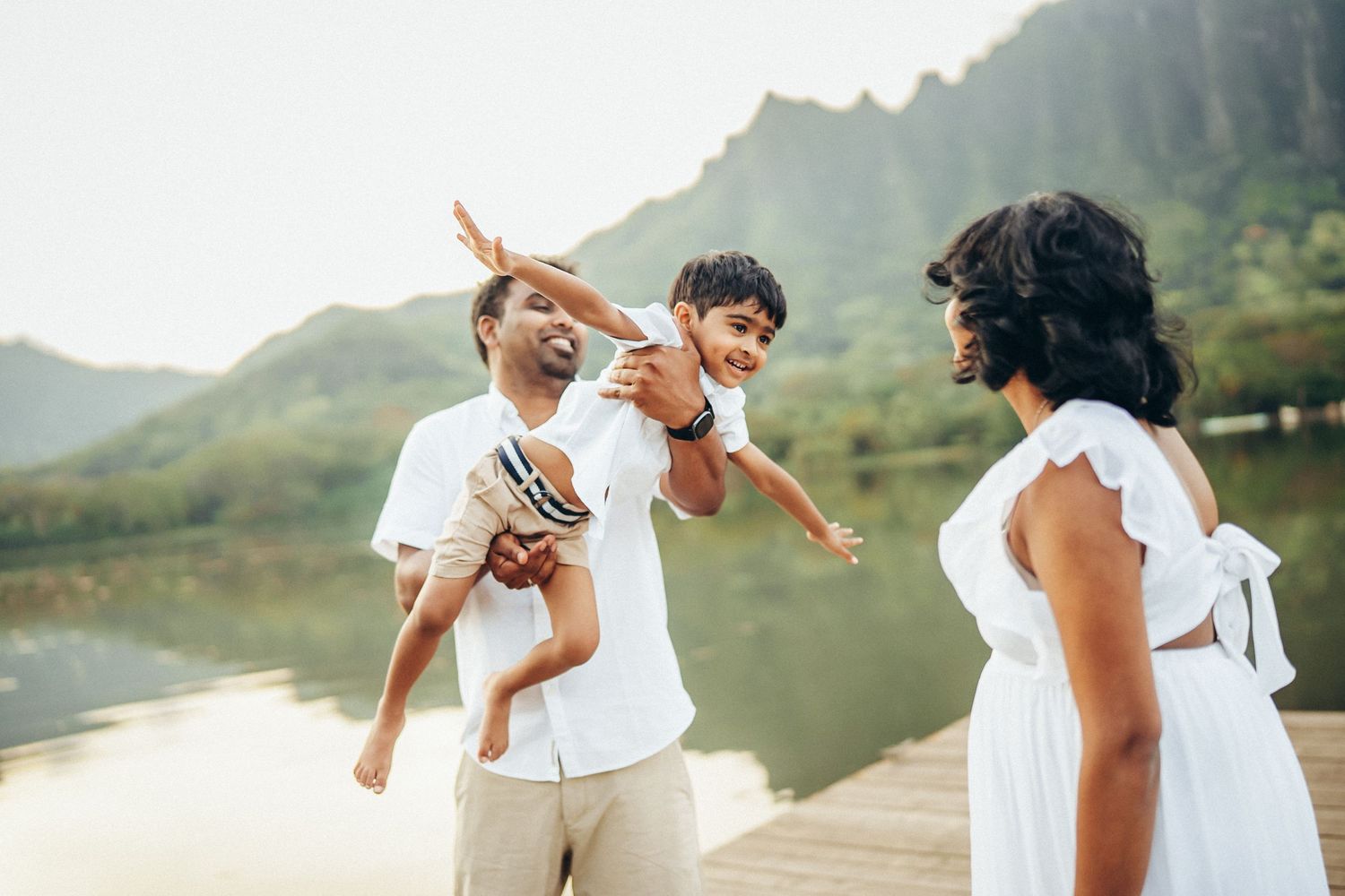 Happy family photoshoot at Secret Beach. Father carrying son on shoulders near Kualoa Ranch, Oahu. Candid moments in a tropical paradise.