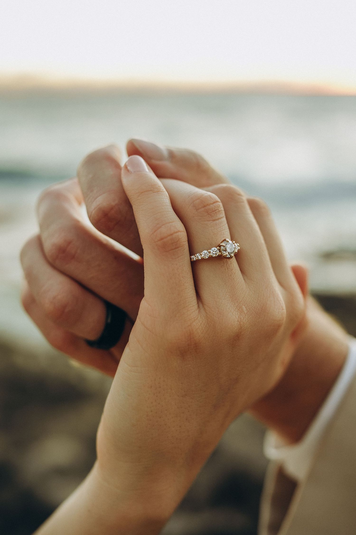 Close-up of wedding rings and hands at a Ko Olina beach wedding. Detail shot of an engagement ring and wedding bands during a destination ce