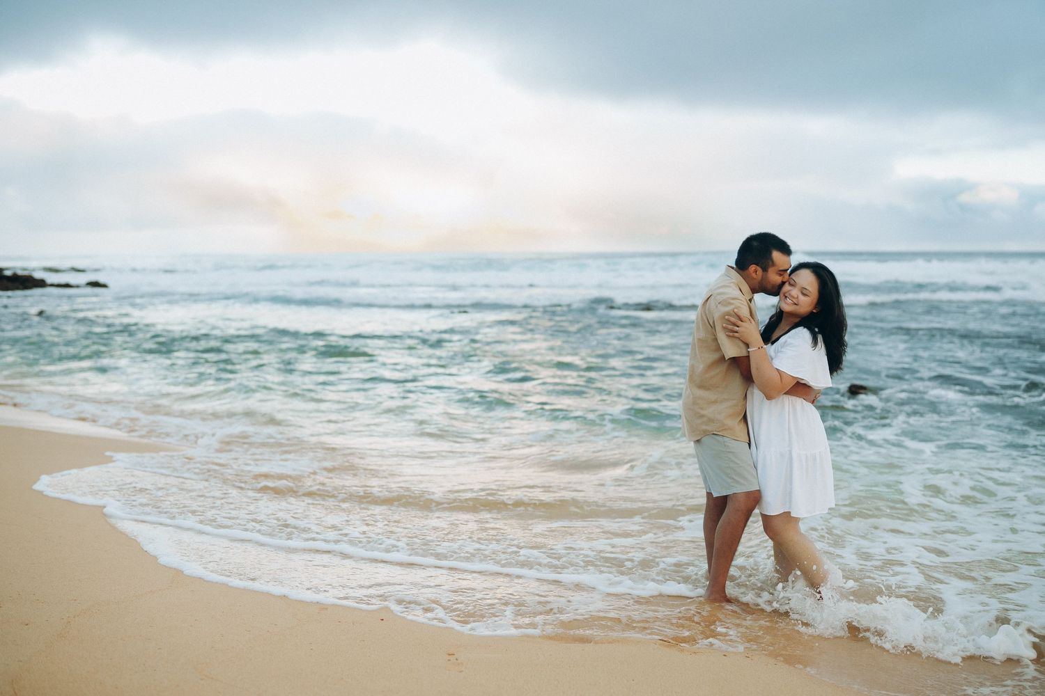 Couple embracing at the water's edge on Sandy Beach, Oahu couples photographer, Hawaii beach session