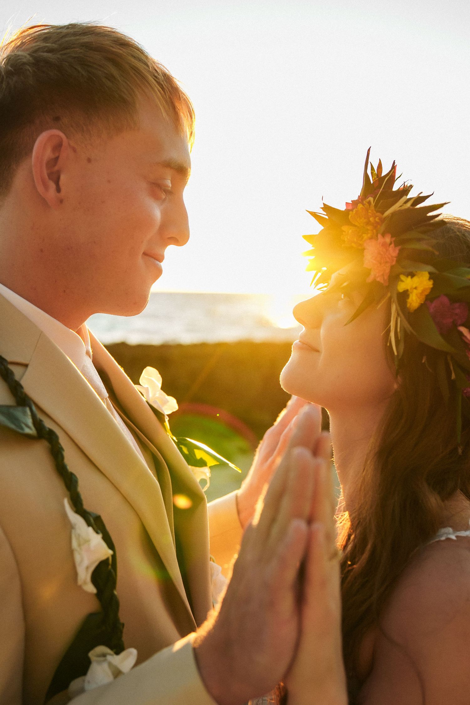 A soulful close-up of a bride and groom during a sunset ceremony. The warm backlighting perfectly captures the couple's connection and highl