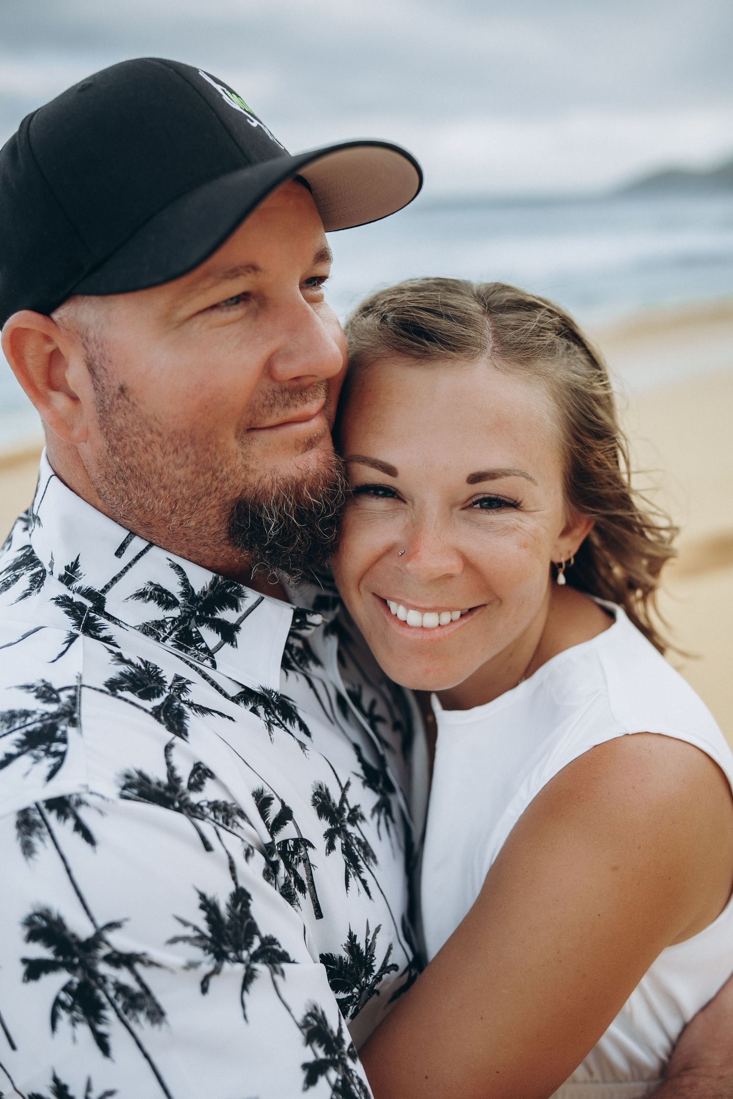 Smiling couple in a close hug on the sand, Sandy Beach couples photographer on Oahu, Hawaii beach session