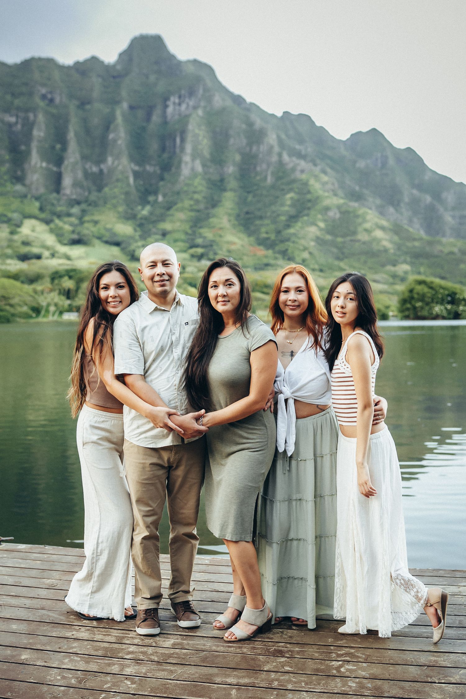 Family photoshoot at Kualoa Ranch, Oahu. Large group portrait on a dock at Secret Beach. Epic mountain views and island vibes.