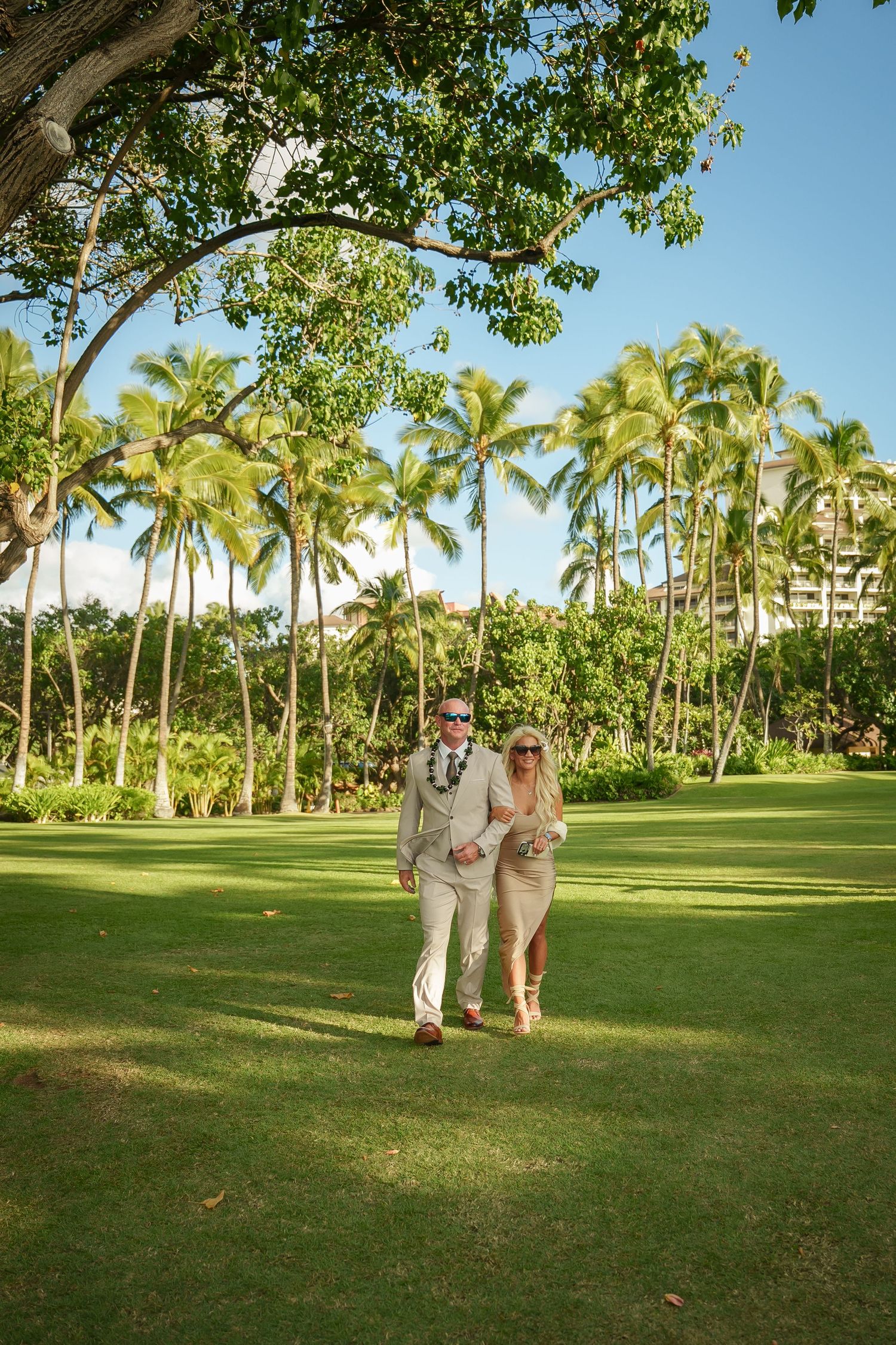 Bride and groom walking through the palm grove at Four Seasons Resort Oahu at Ko Olina. Cinematic wedding photography in Hawaii.