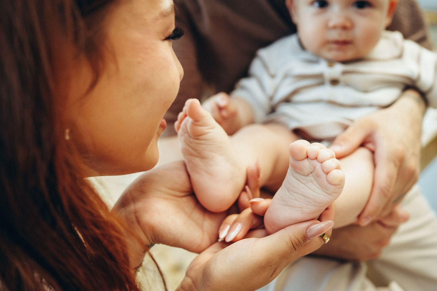 Hawaii family photoshoot details. Close-up of baby feet at Secret Beach, Oahu. Professional photography near Kualoa Ranch.