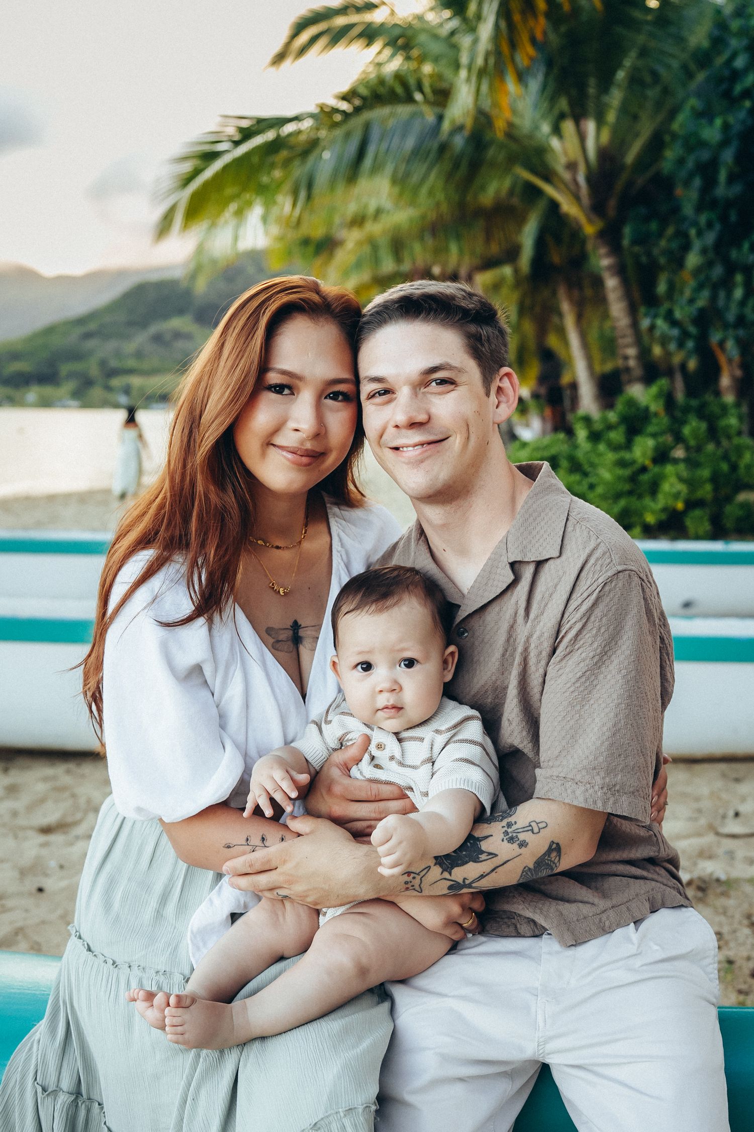 Hawaii family photoshoot. Parents with a baby at Secret Beach, Oahu. Beautiful island portraits taken near the iconic Kualoa Ranch.