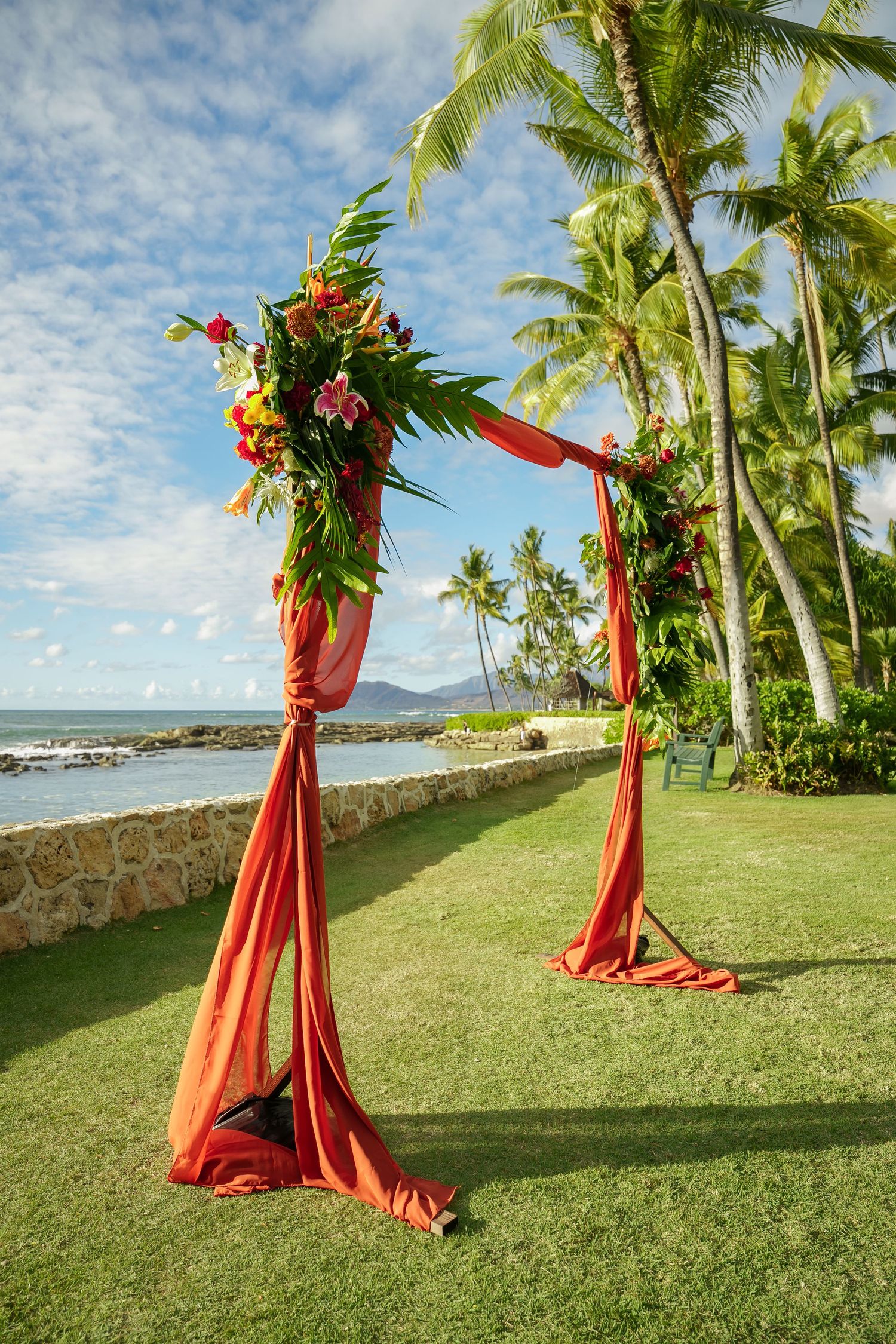 Floral wedding arch at Pohaku Point, Four Seasons Oahu at Ko Olina. Oceanfront wedding ceremony setup with tropical decor.