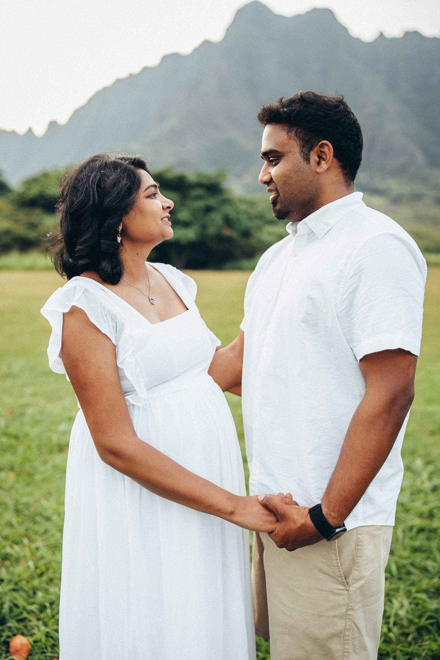 Secret Beach family photoshoot, Oahu. A couple posing in a lush green valley at Kualoa Ranch. Professional island photography.