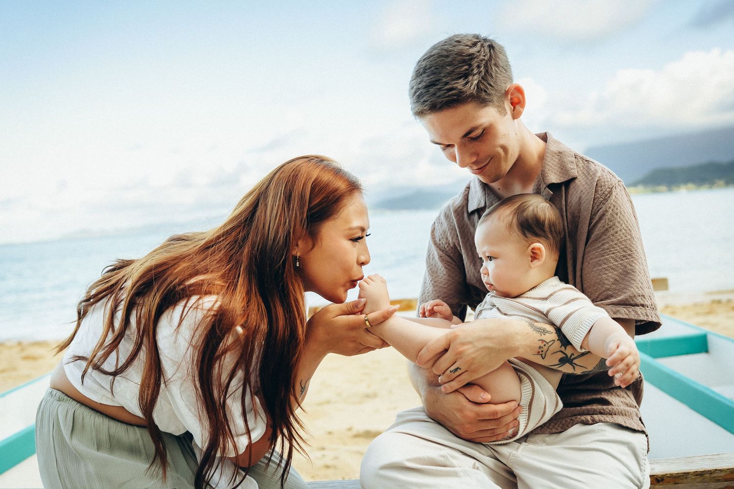 Secret Beach family photoshoot, Oahu. Heartfelt moments with a newborn at Kualoa Ranch area. Authentic Hawaii lifestyle photos.