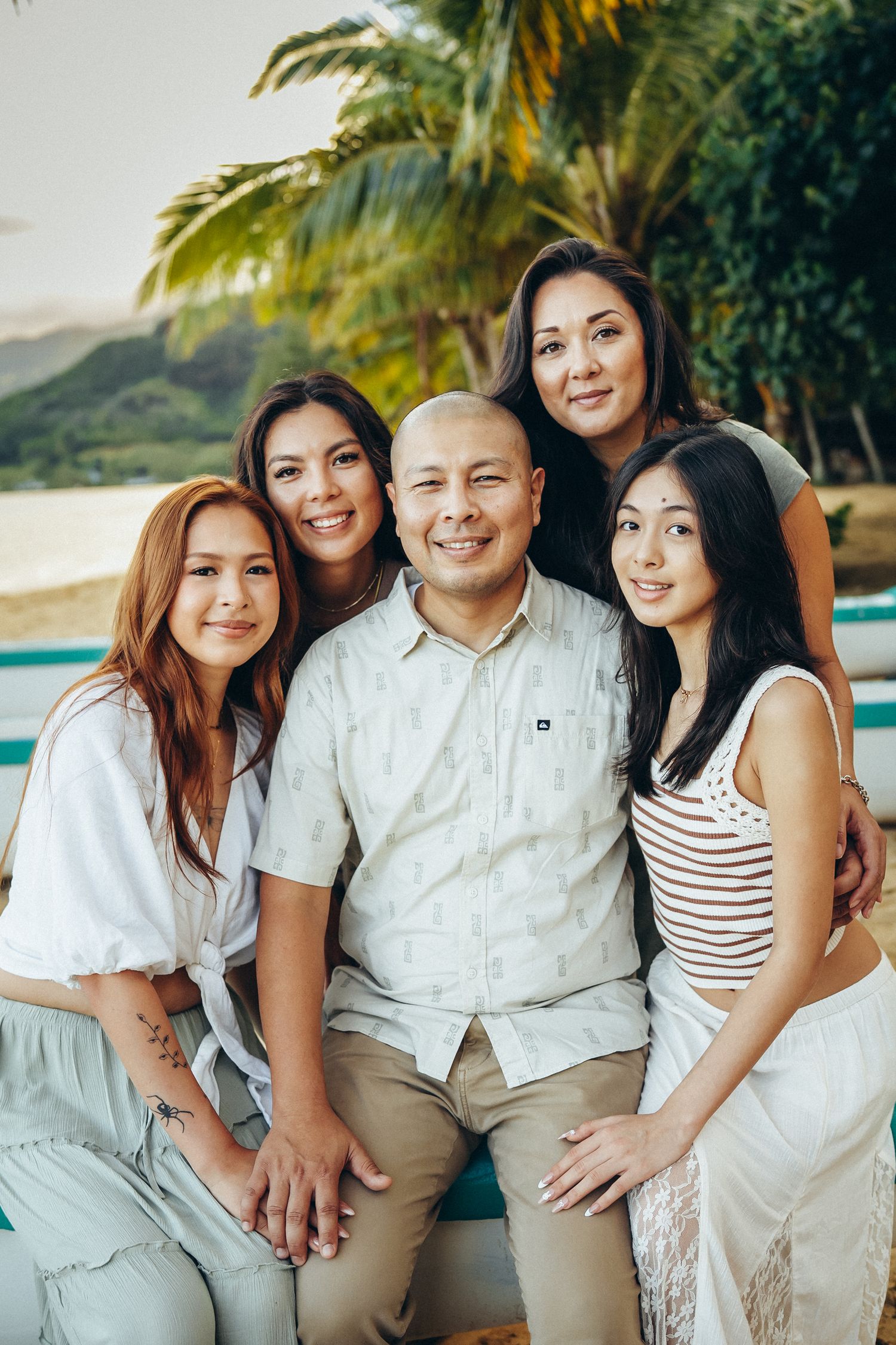 Professional photographer in Oahu. Full group portrait during a family photoshoot at Kualoa Ranch area, Secret Beach. Classic Oahu.
